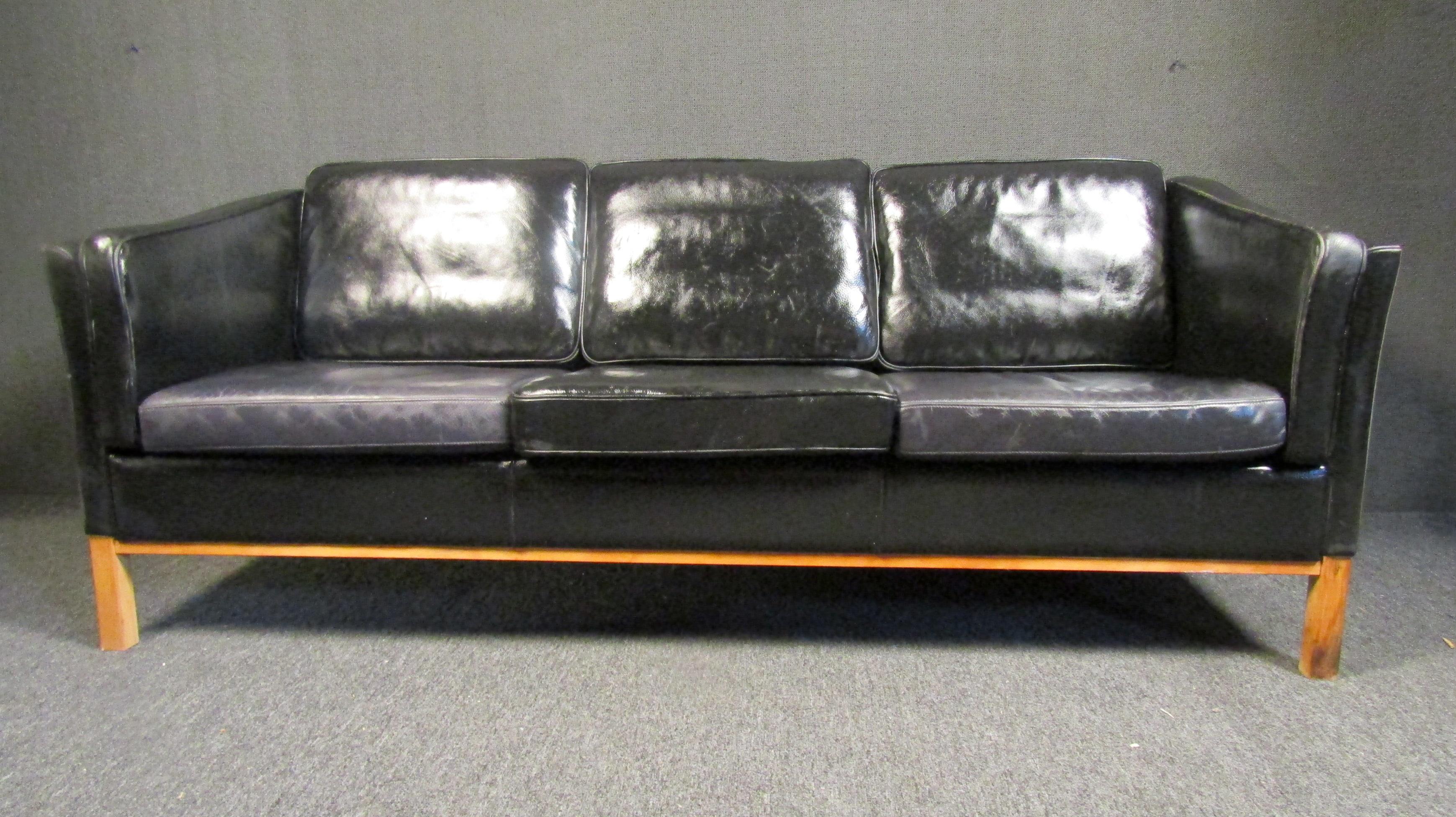 Mid-century modern three seater sofa by stouby in black leather featured on a sturdy wood frame. This sofa comes with comfortable cushions throughout. 

Please confirm the item location with the dealer. (NJ/NY).