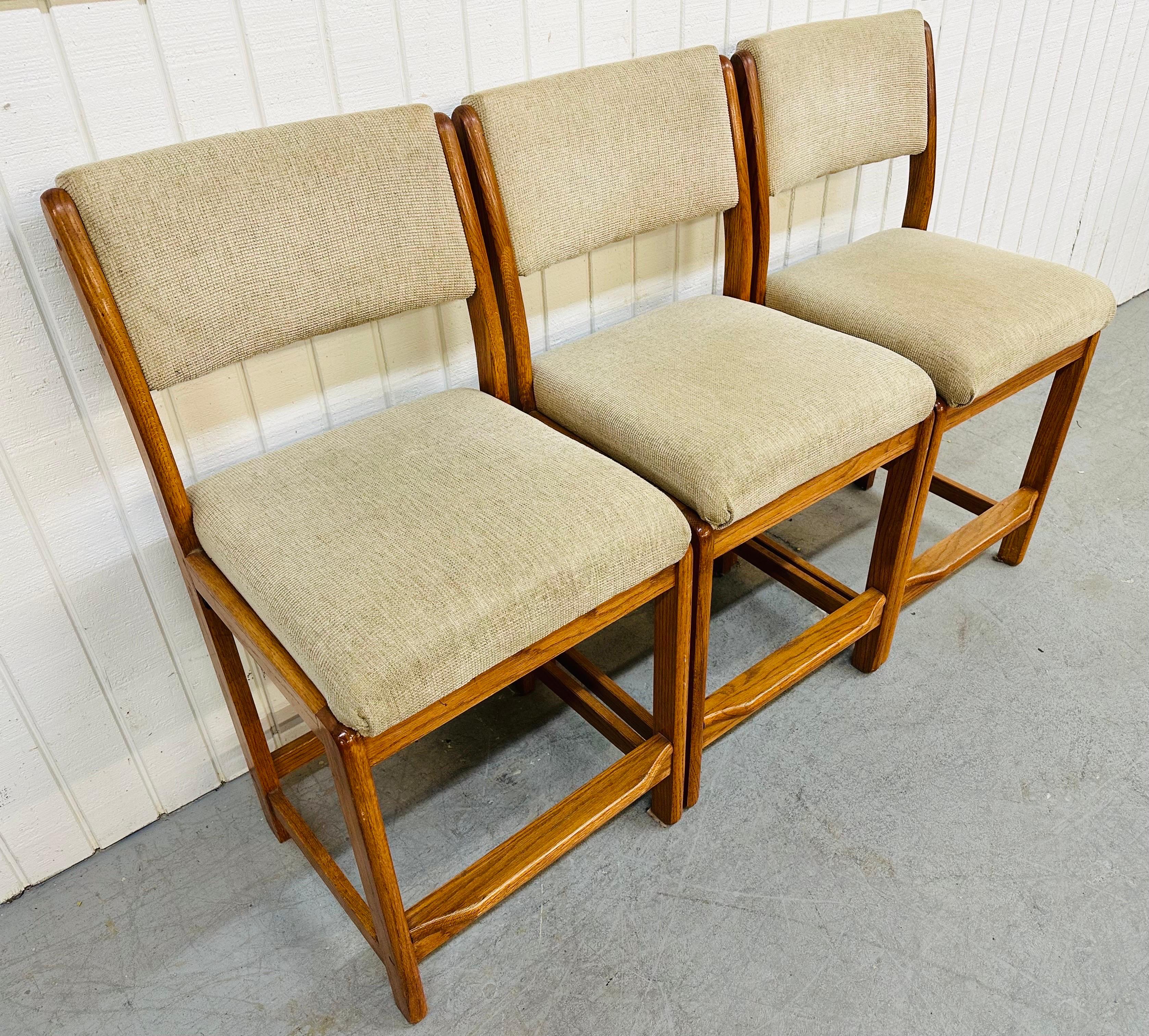 This listing is for a set of three vintage Danish Modern Bar Stools. Featuring oak frames with a teak color finish, tan upholstered seats, and tan upholstered back rests. This stools could be used for your counter or bar!