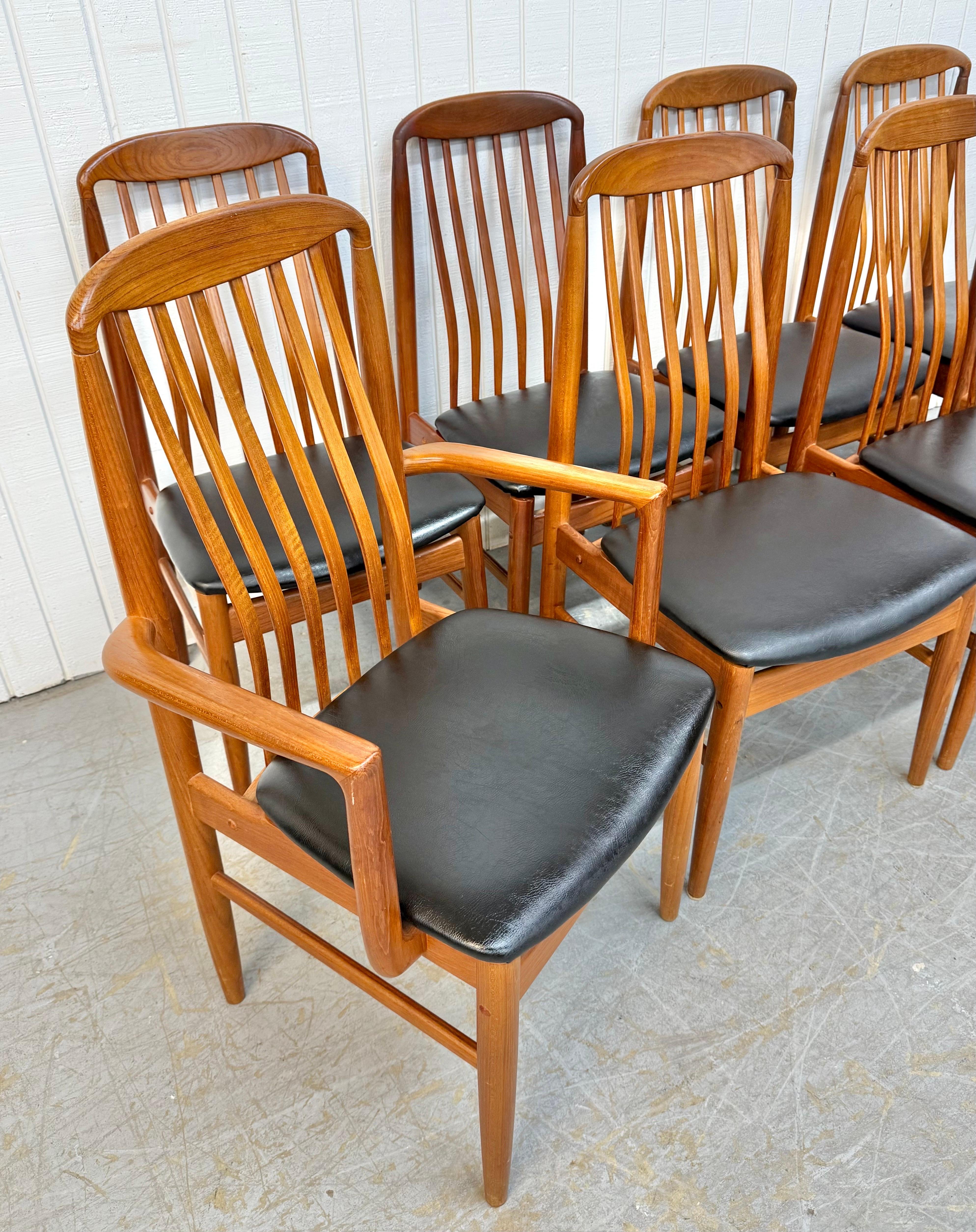 This listing is for a set of eight Vintage Danish Modern Benny Linden Teak Dining Chairs. Featuring a high curved spindle back design, two arm chairs, six side chairs, modern legs, new black vinyl upholstered seats, and a beautiful teak finish. This