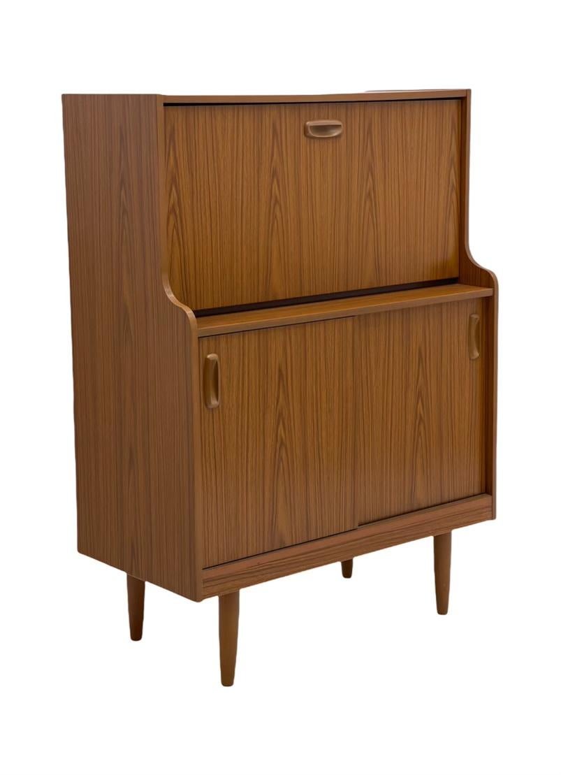 Questo elegante mobile vintage è dotato di uno scomparto a ribalta e di gambe affusolate. Un colore splendido che si aggiunge a uno stile moderno di metà secolo. 

Dimensioni. 32 L; 16 P; 44 1/2 H.