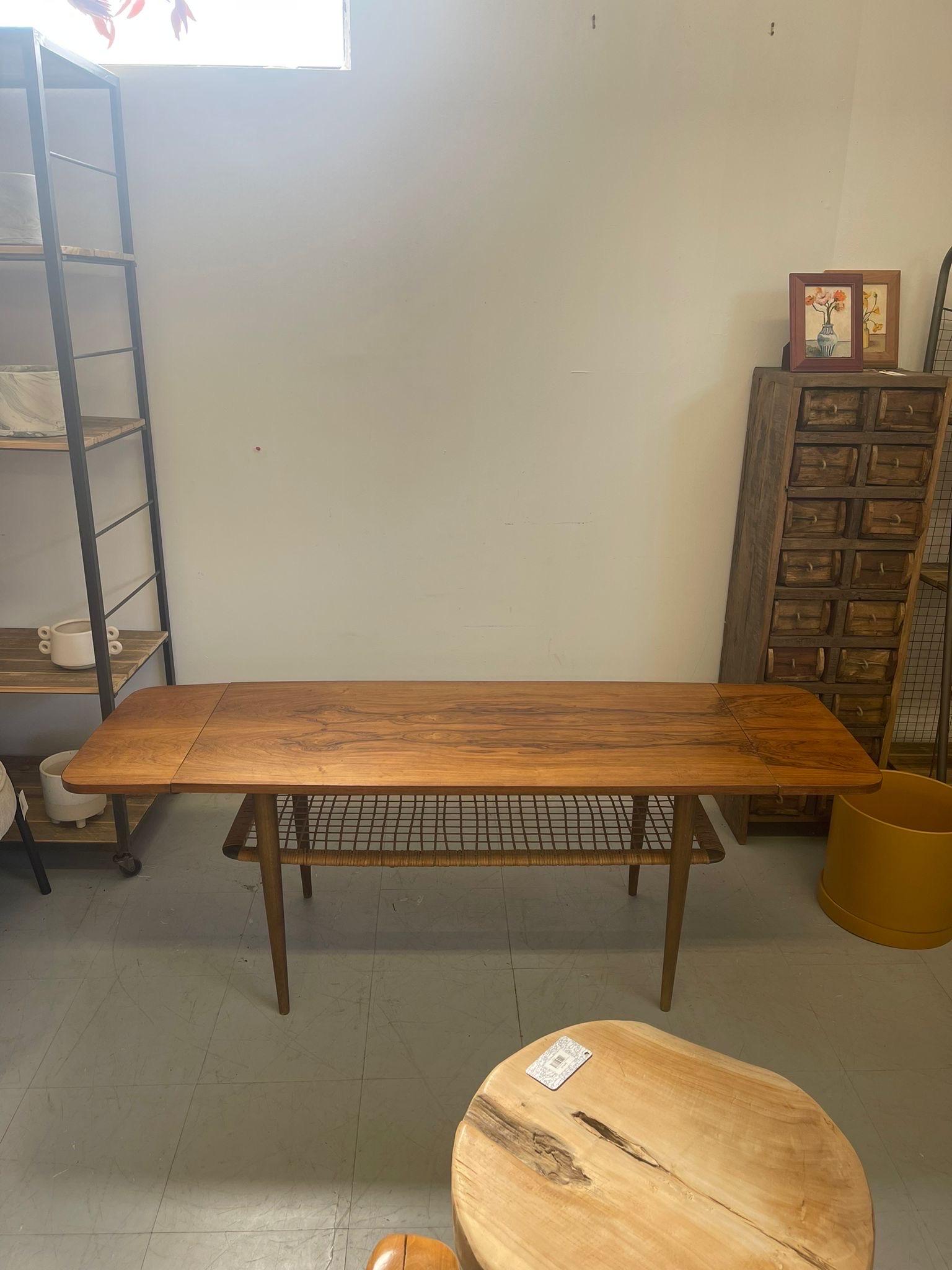 Coffee Table with Symmetrical Wood Grain. Lower Shelf is Wicker, wrapped around Sides.Tapered Legs. Vintage Condition Consistent with age. Wear and Tear as pictured

Dimensions. 61 W ; 20 D ; 25 H
Lower Shelf. 40 W ; 14 D