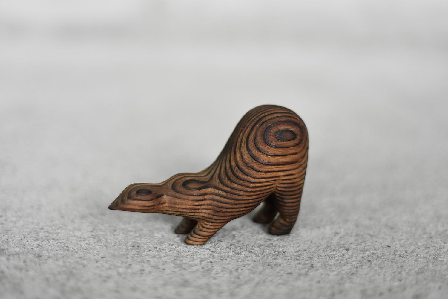 This wooden Badger figurine was produced in Denmark during the 1960s. It is hand-made from a single piece of wood, with a distinct brushing that brings out the natural structure of the wood and strong grain. The minimalist form with simplified