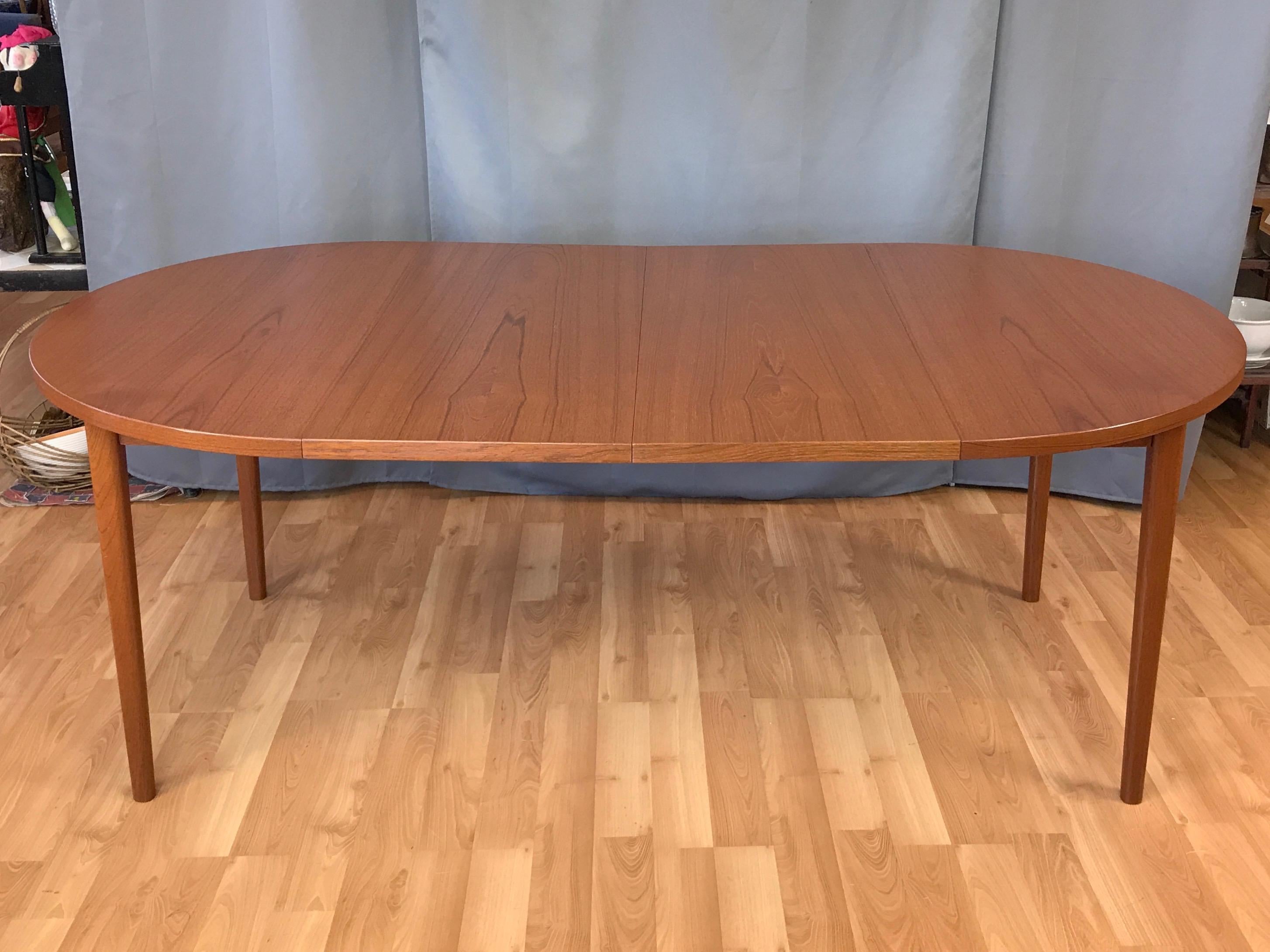 A 1960s Danish modern extendable teak dining table with two leaves.

Super clean lines with a very nicely figured matched grain top. Solid teak rounded square legs with a slight taper. A handsome design equally at home in a vintage, Scandinavian