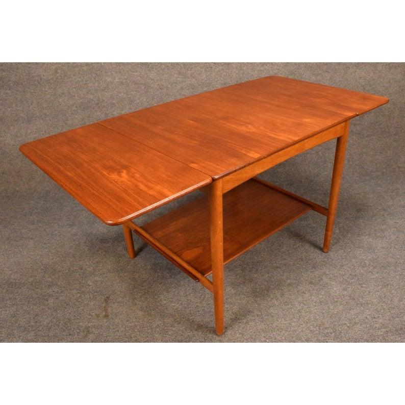 Here is, from acclaimed designer Hans Wagner, the AT32 drop-leaf table in teak and oak manufactured by Andreas Tuck in the 1960s in Denmark.
This special piece, recently imported from Copenhagen to California before its restoration, features a