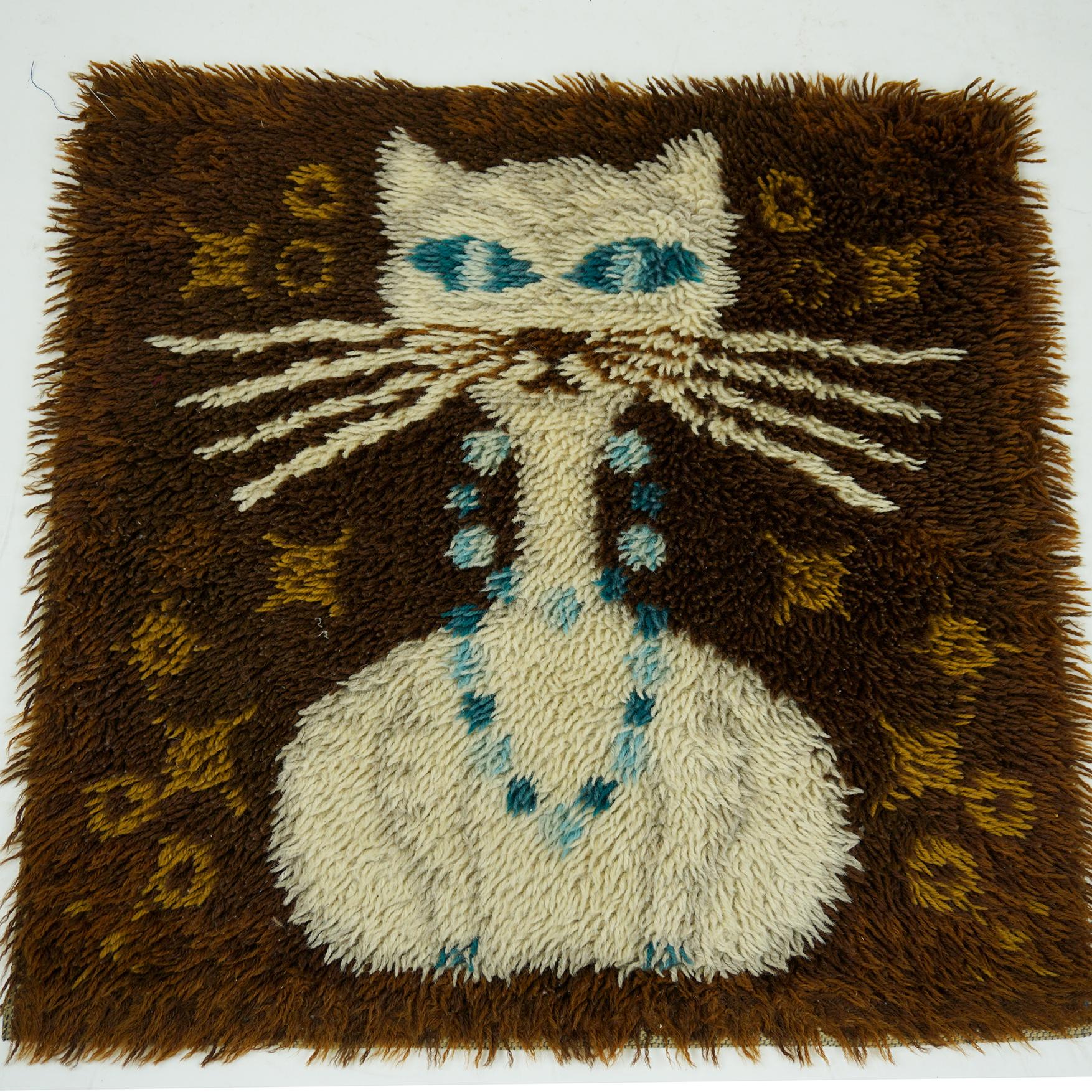 Charming and very decorative design carpet in wonderful shades of brown and blue with a sitting white cat. In beautiful original condition without damages.
It is made from wool in Denmark 1960s and can be used on the floor or as well as a wall