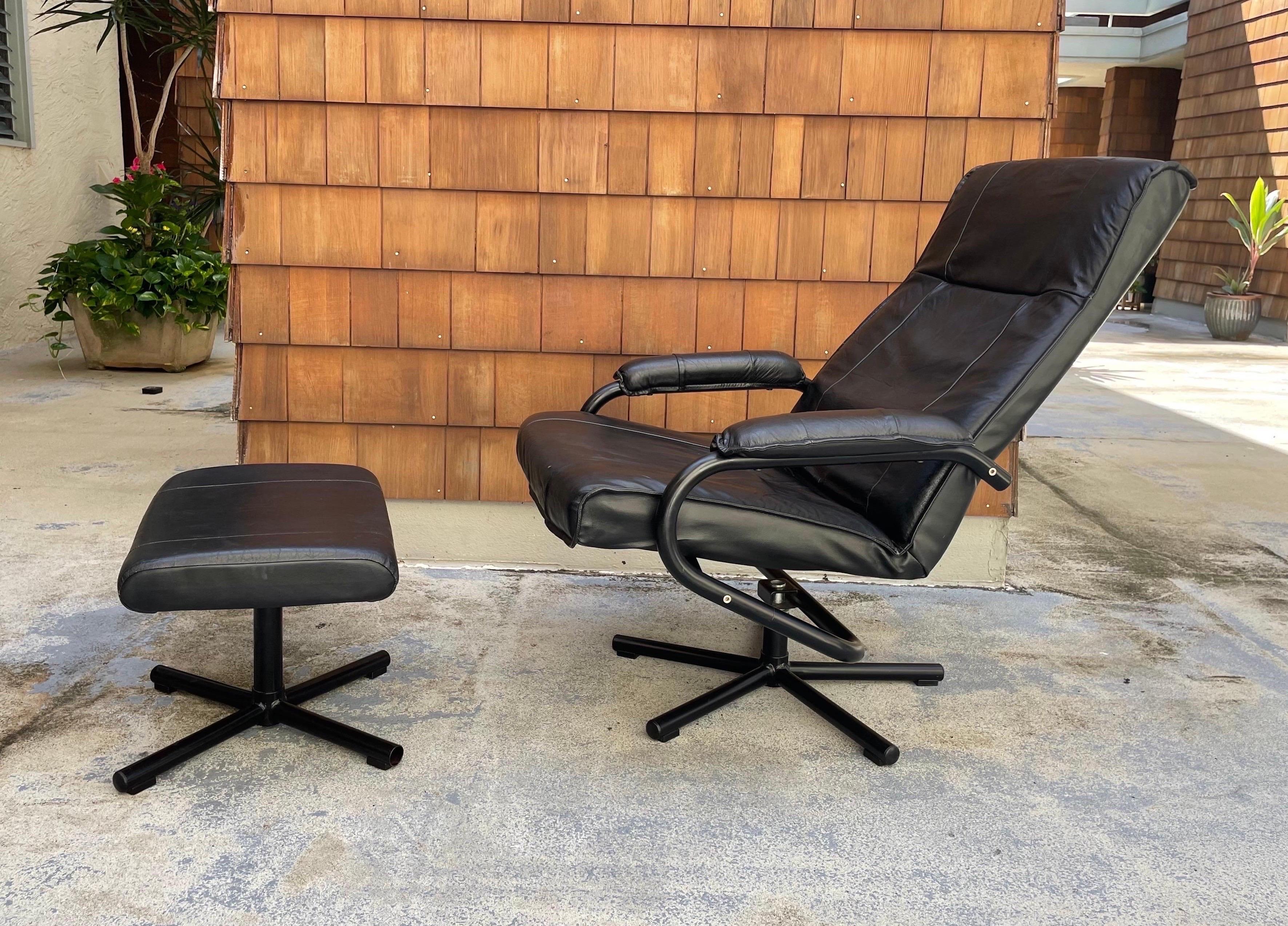 A black leather recliner with matching footstool by Kebe. Made in Denmark circa 1980s. High-quality construction, sleek design offering maximal comfort. Model is 6'4