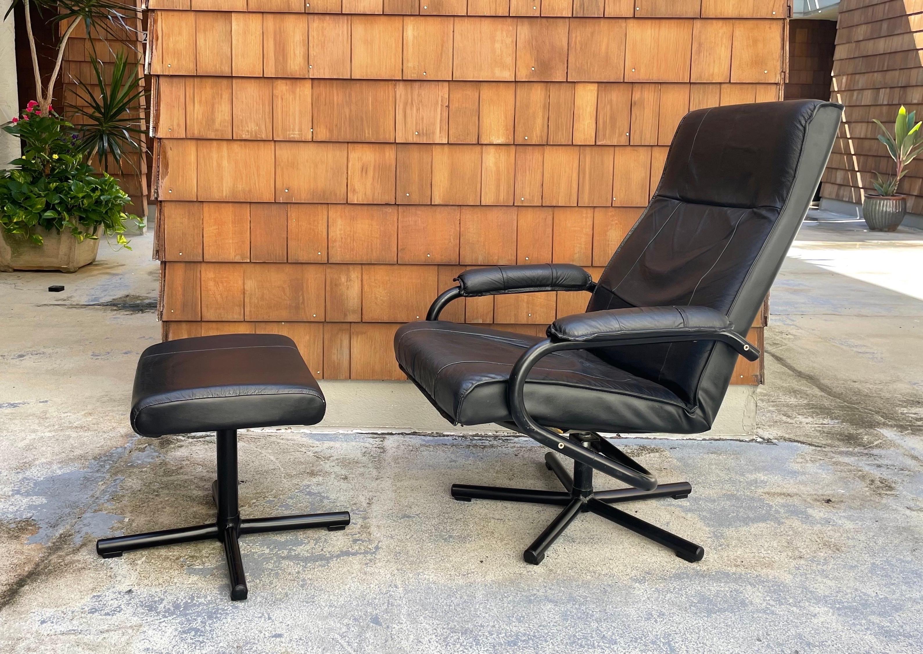 A black leather recliner with matching footstool by Kebe. Made in Denmark circa 1980s. High-quality construction, sleek design offering maximal comfort. 

Measures: Overall height 40.5”
Seat height 17.5”
Seat depth 20”
Seat width 23”
Width between