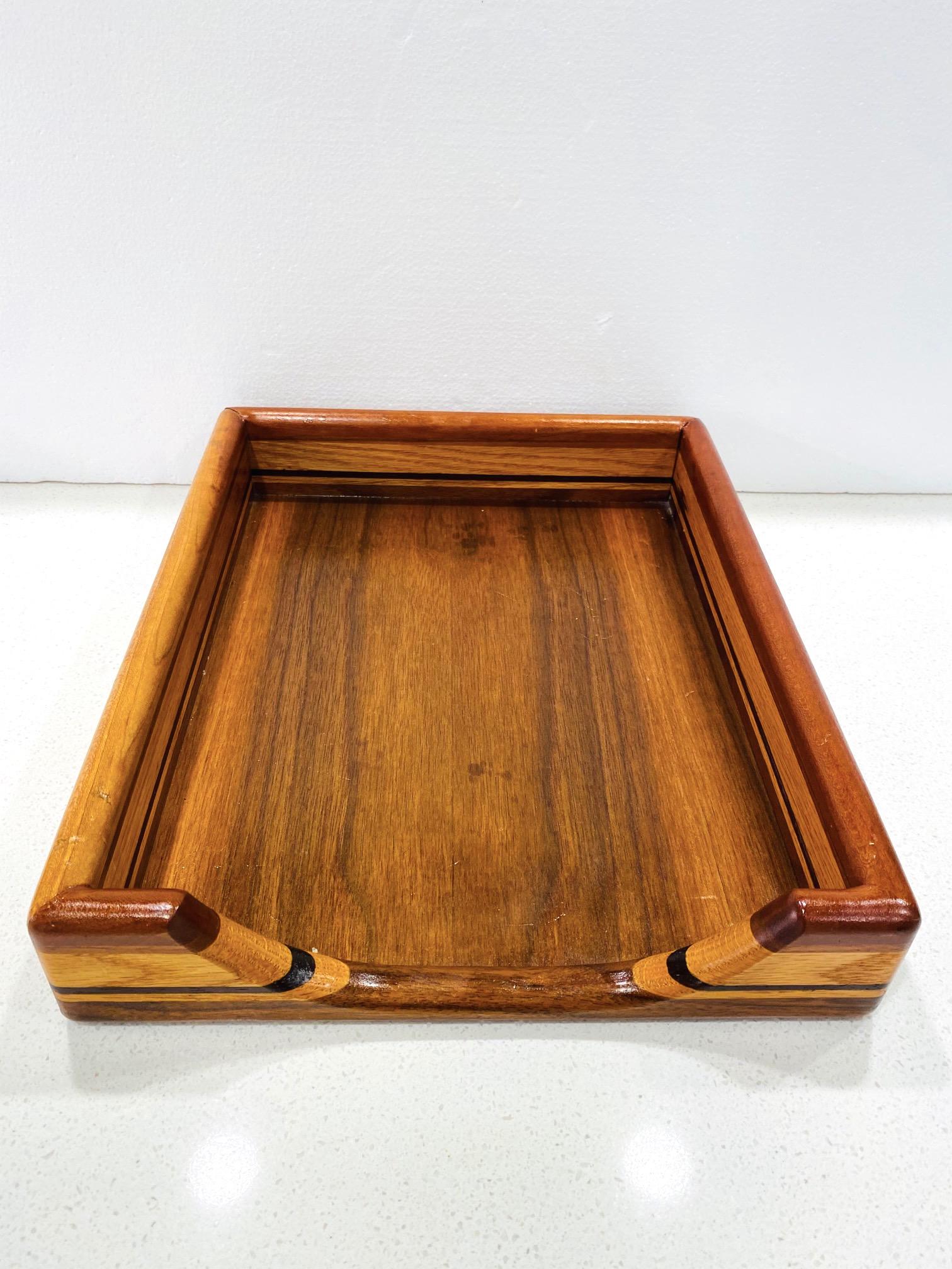 Mid-Century Modern paper and letter tray with streamline design, circa 1970. Comprised of handcrafted teak, maple, and walnut woods, creating stunning stripes with variegated wood tonalities and colors, and with beautiful wood grains throughout.
