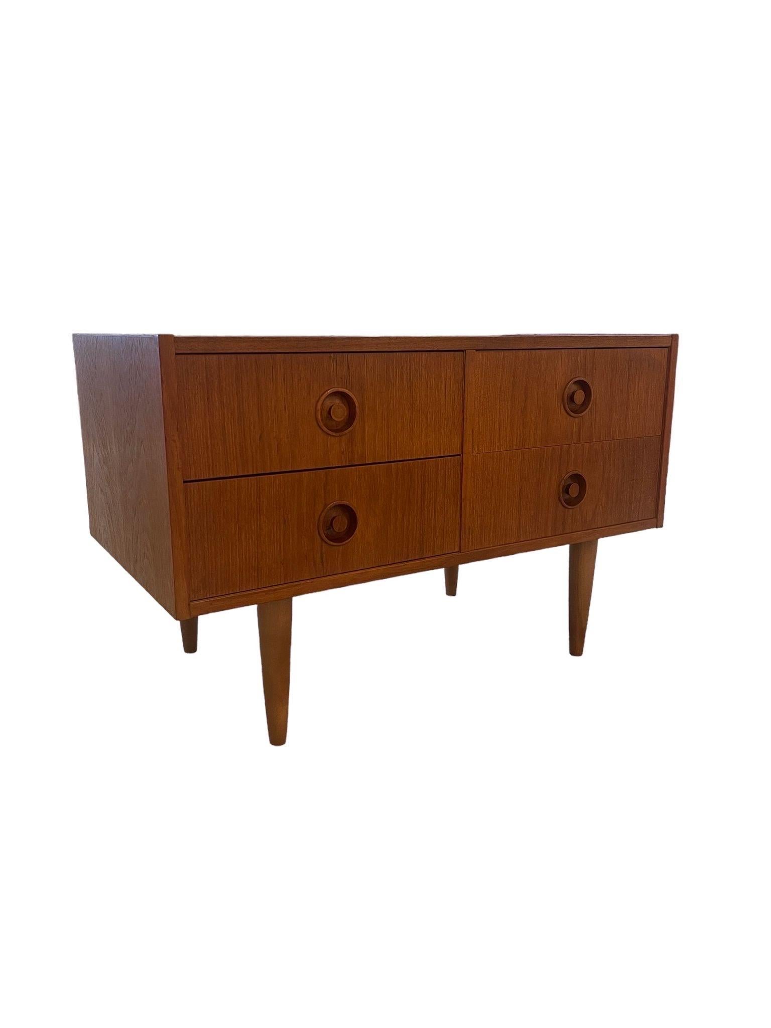 This Danish Modern Dresser has Four Drawers, Tapered Legs and Classic Wooden Circular Handles . UK Import. Vintage Condition Consistent with Age as Pictured.

Dimensions. 31 1/2 W. ; 17 D ; 21 H