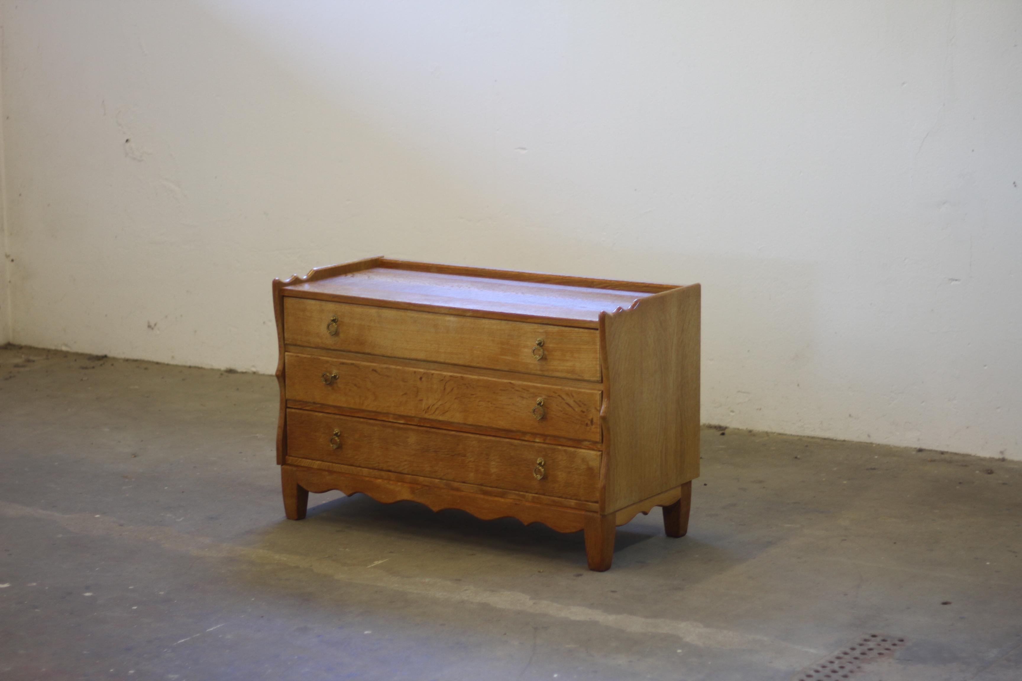 Un mobile o una credenza compatta danese della metà del secolo scorso realizzata in quercia nordica. Prodotto in Danimarca negli anni '60 e spesso attribuito al famoso designer danese Henning Kjærnulf. Kjærnulf è riconosciuto a livello mondiale per