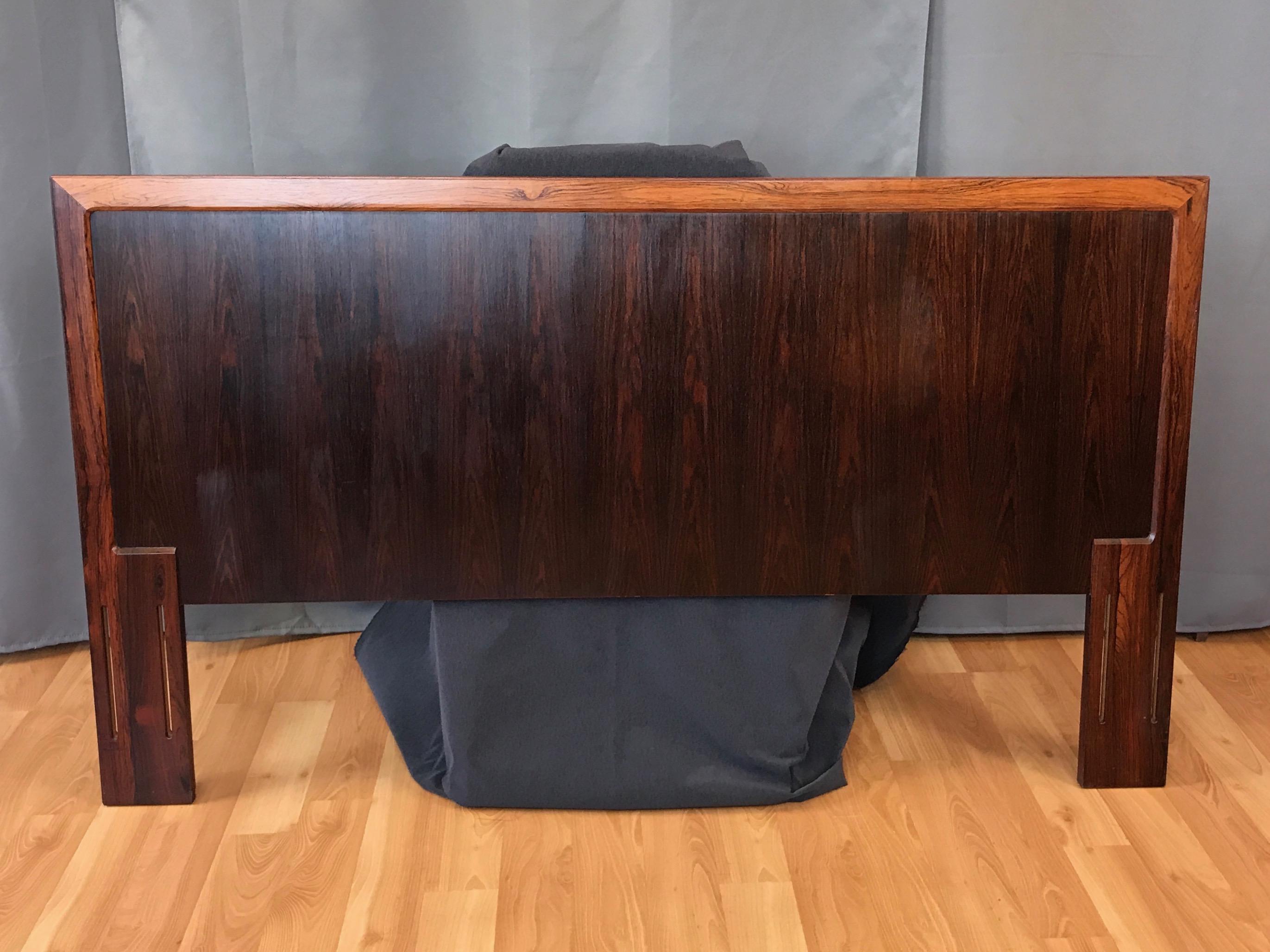 An exceptional late 1960s Danish Modern full or queen size rosewood headboard.

Distinguished by a fantastic expanse of strikingly figured bookmatched Brazilian rosewood veneer. Framed by three finely crafted segments of solid rosewood with