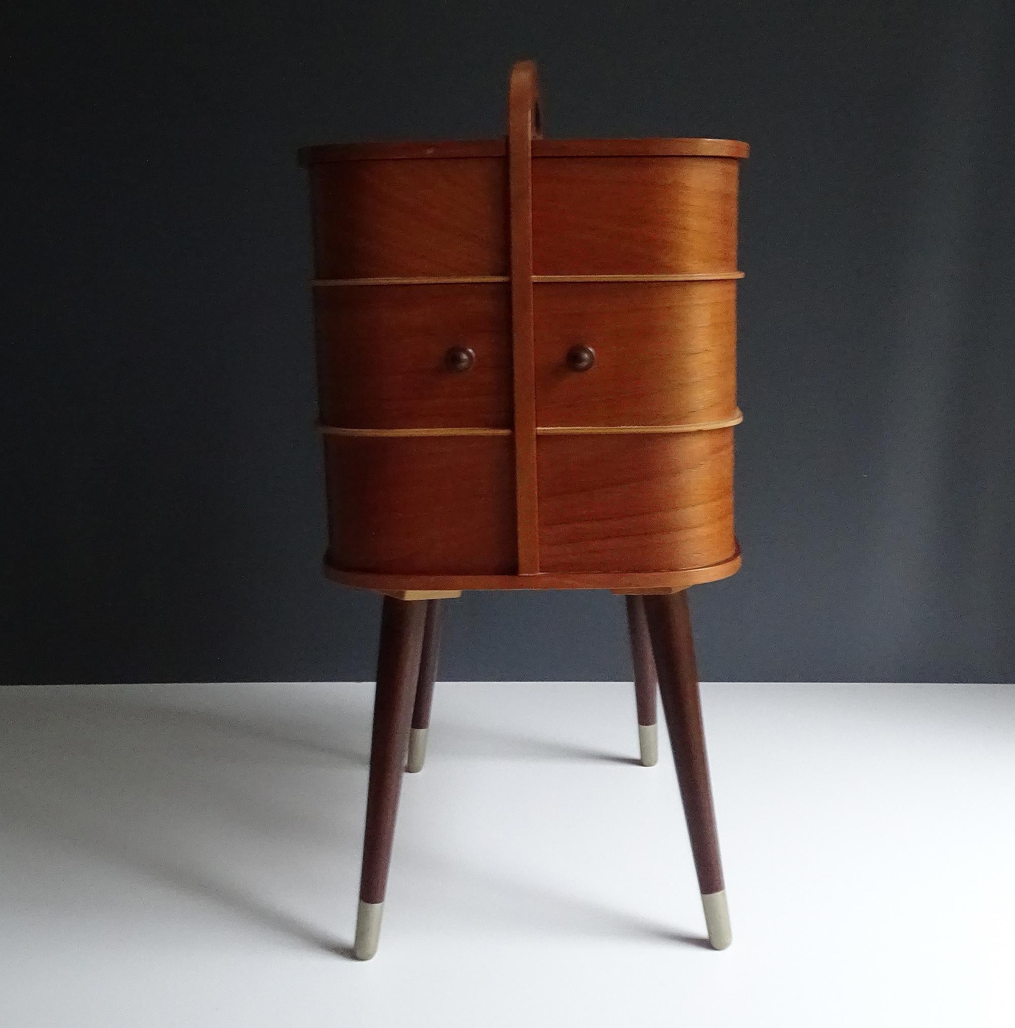 Stunning original Danish modern midcentury 1950s-1960s portable storage box with handle on top.
The box features 2 drawers which rotate sidewise revealing underneath 2 more compartments, the uppermost levels have also compartments under side hinged