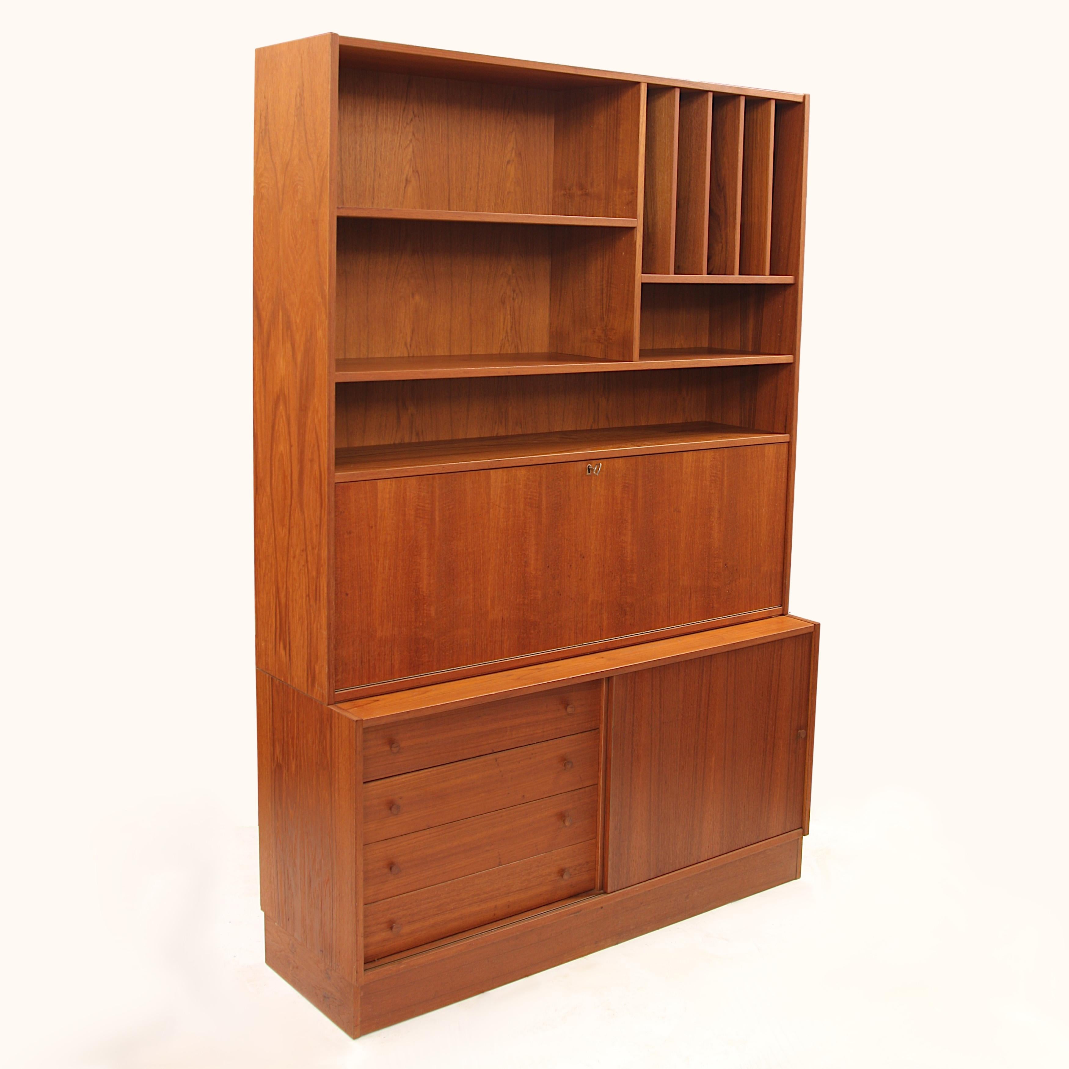 Vintage Danish Modern teak bookcase cabinet and secretary desk by Domino Mobler.

Cabinet Features:

Beautiful teak Veneer
Open Upper Shelves w/ 11.25