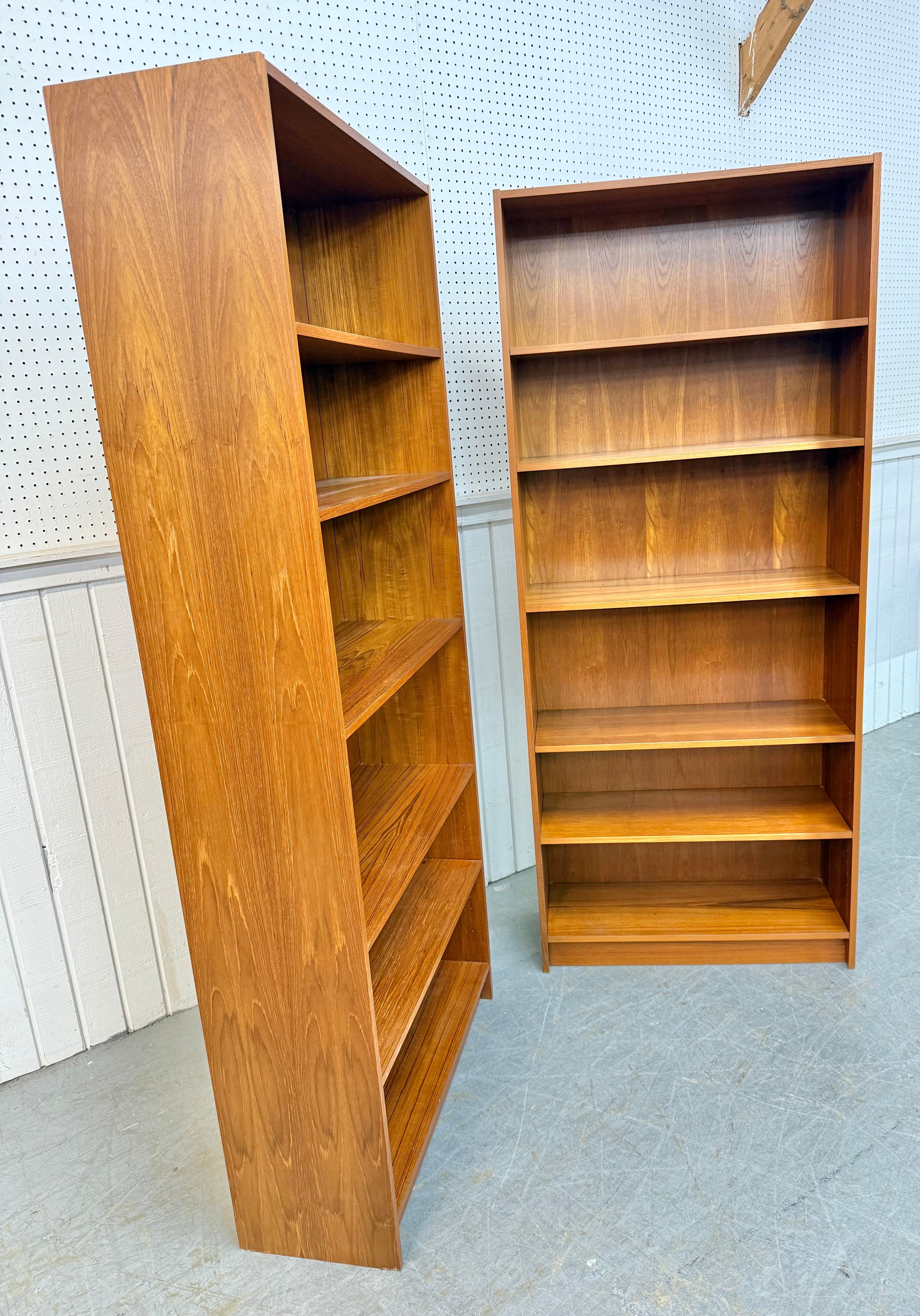 Questo annuncio si riferisce a una coppia di librerie d'epoca in teak danese moderno. Caratterizzato da un design lineare, cinque ripiani per riporre gli oggetti, una base a zoccolo e una robusta struttura in legno di teak. Si tratta di