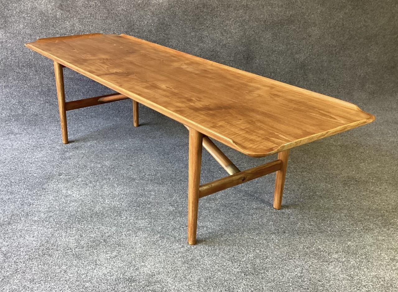 An incredible piece of Danish Modern Design attributed to Kurt Ostervig, in soil teak & brass. Book-matched top section, flanked by a subtle lip or gallery, with diagonal struts connecting the center of the top to the legs. A super elegant design