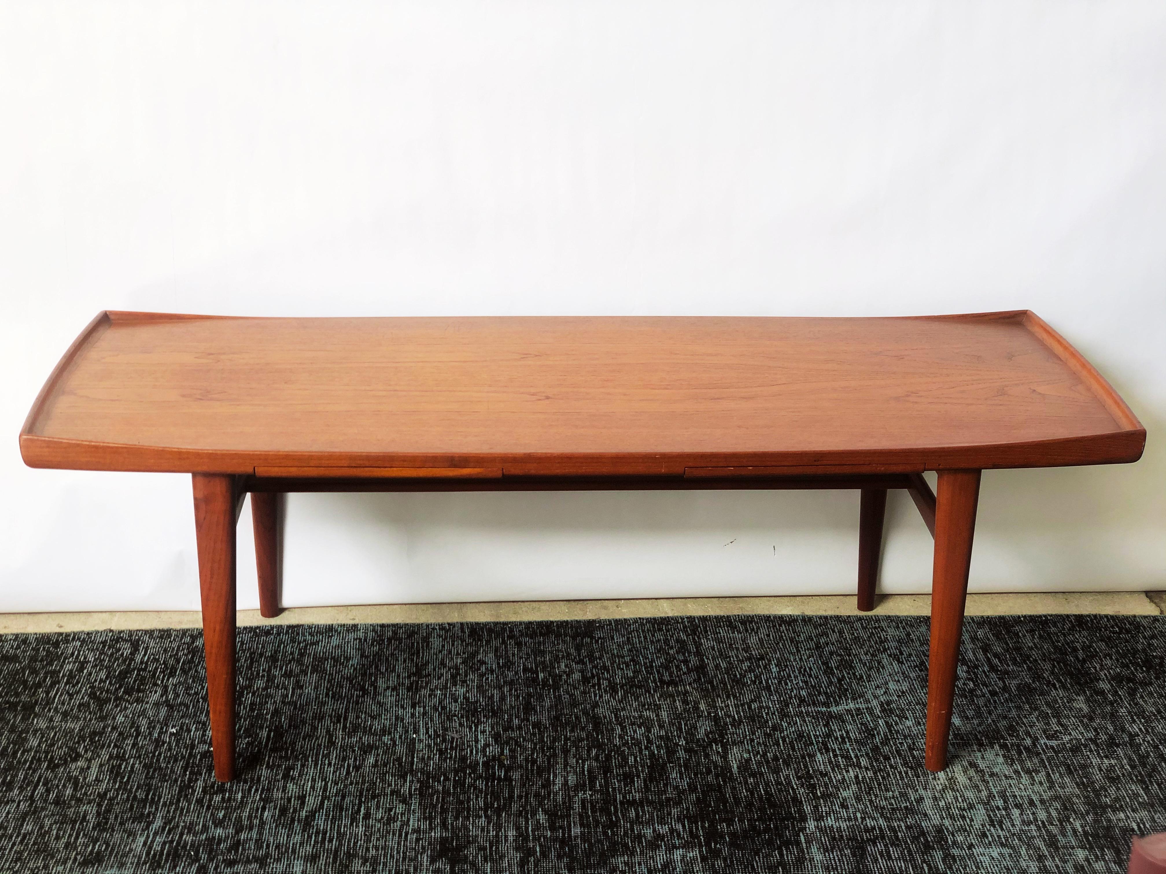 This vintage Danish modern teak coffee table by Swedish designer Alf Svensson is in overall great condition. The table features pull out trays that extend from either direction. The olive laminate provides an excellent surface area for beverages.