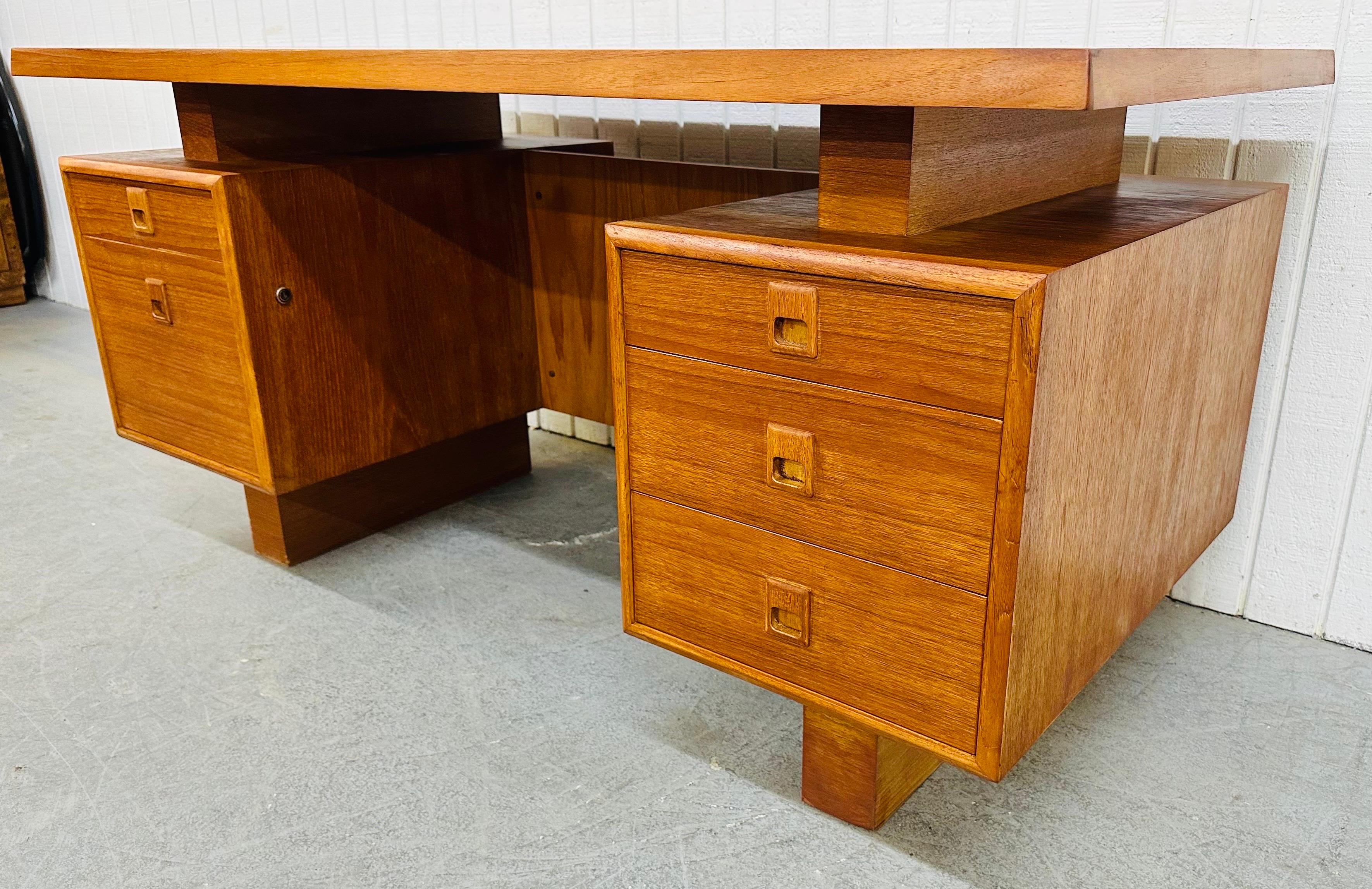 This listing is for a Vintage Danish Modern Teak Executive Desk. Featuring a straight line floating design, large rectangular teak top, two drawers on the left, three drawers on the right, sculpted wood pulls, and a beautiful teak finish. This is an