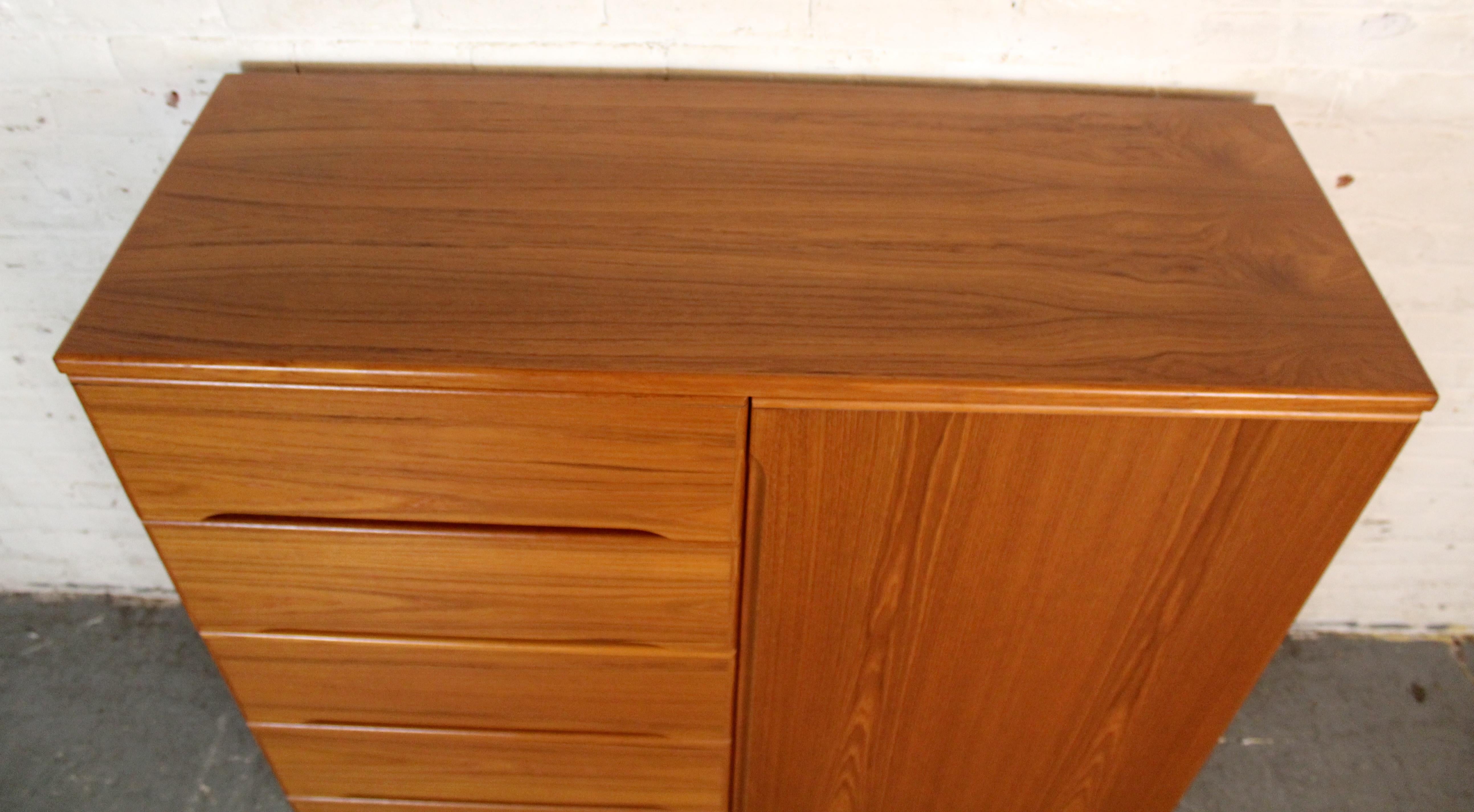 Armoire danese moderno in teak, realizzato a metà del XX secolo con linee pulite e teak caldo e ricco di venature. Il lato sinistro presenta cinque cassetti a scorrimento fluido con tiretti scolpiti che offrono un ampio spazio di archiviazione,