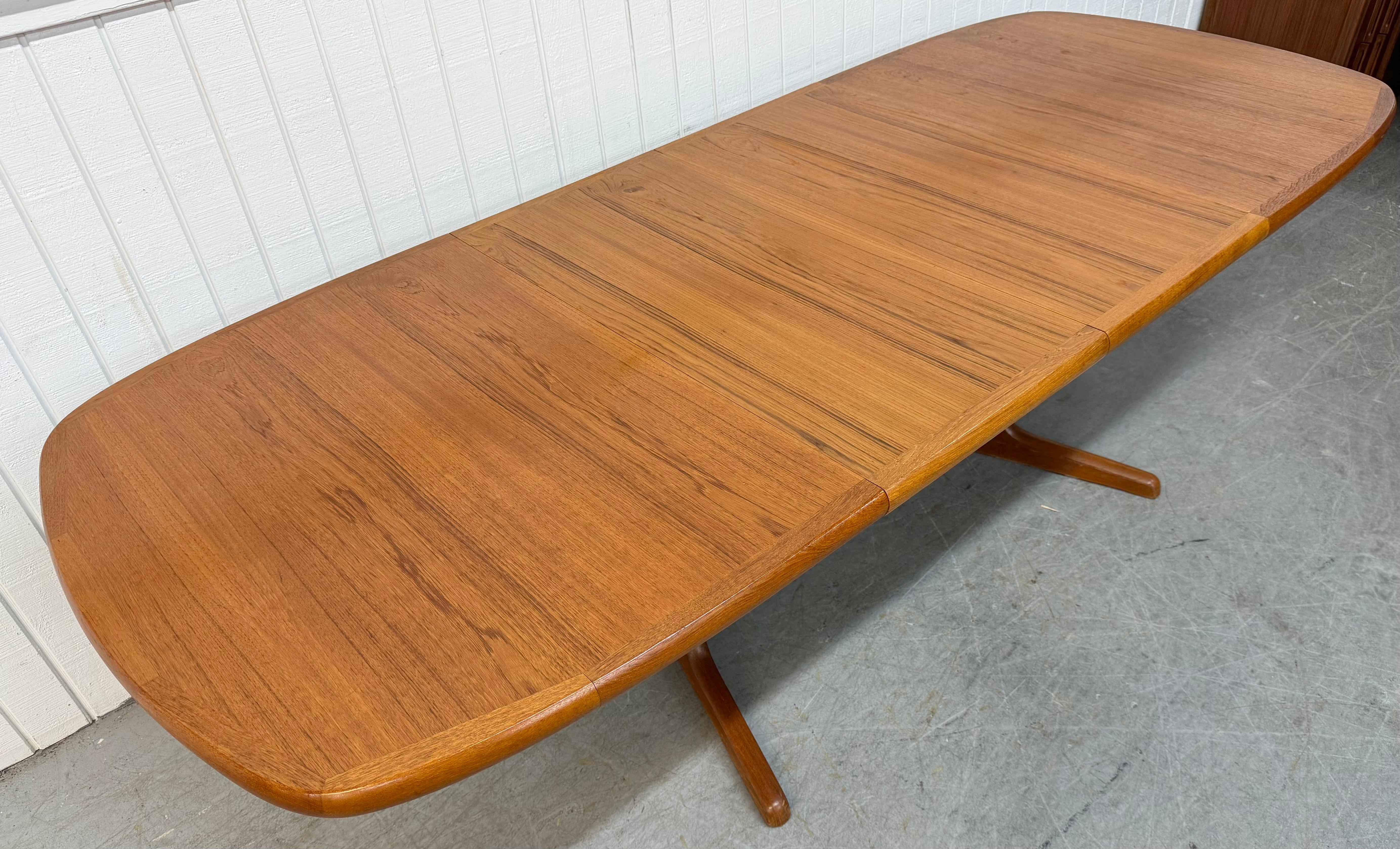 Cette annonce concerne une table de salle à manger ovale en teck d'époque, moderne et danoise. Elle est dotée d'un plateau ovale, de deux allonges qui permettent d'allonger la table jusqu'à I.L.A., d'une base de style piédestal et d'une magnifique