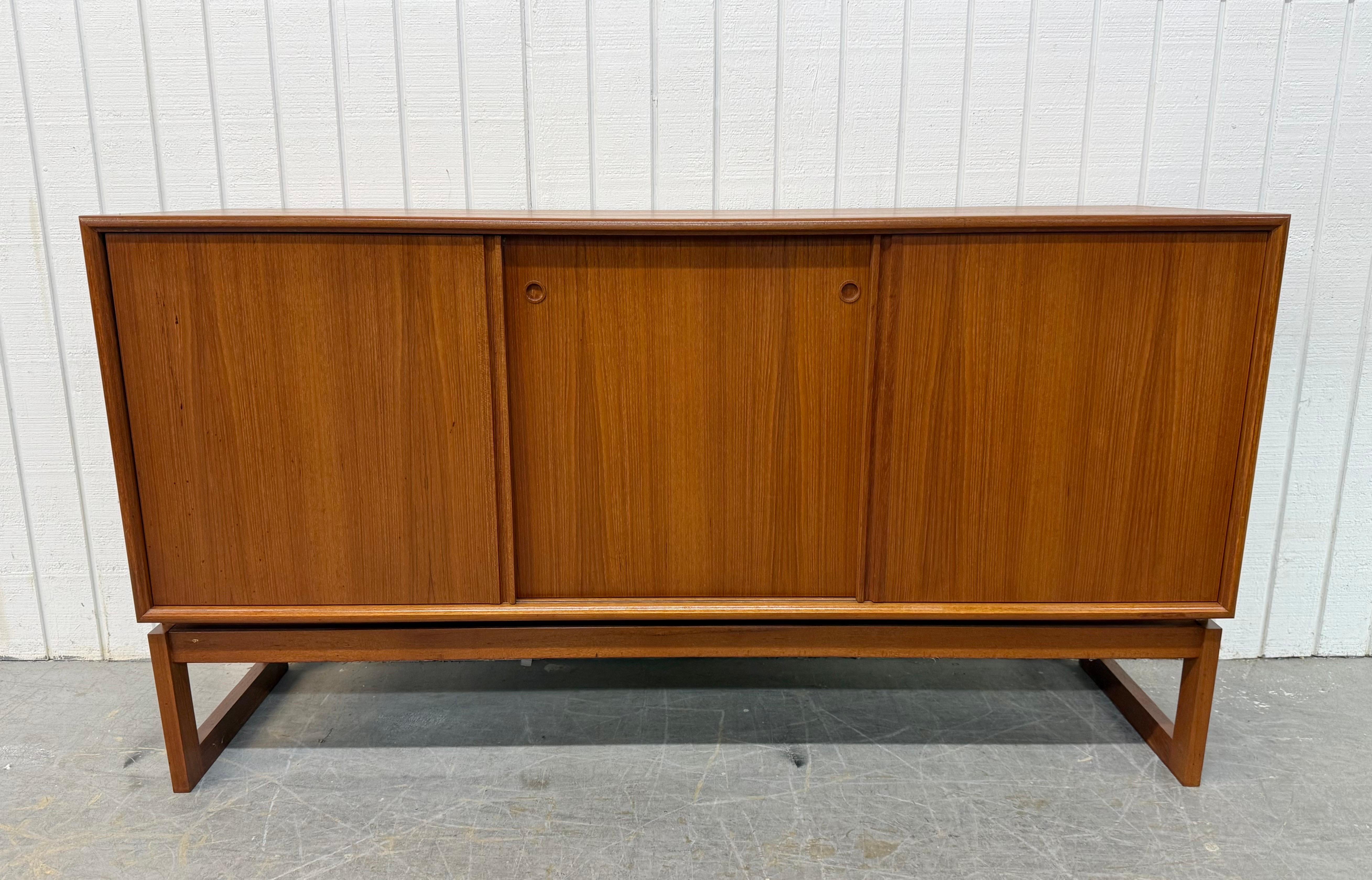 This listing is for a Vintage Danish Modern Teak Sideboard. Featuring a straight line design, sliding doors that reveal storage space, modern legs, and a beautiful teak finish. This is an exceptional combination of quality and Danish design! 