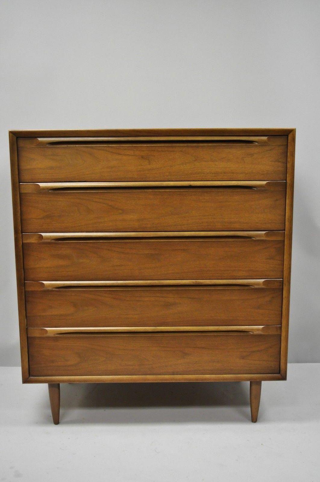 Vintage Mid-Century Modern walnut tall chest dresser with sculpted wood pulls. Item features sculpted wood drawer pulls, beautiful wood grain, serial number #1880-3 DR H-138, five dovetailed drawers, tapered legs, and clean Modernist lines, circa