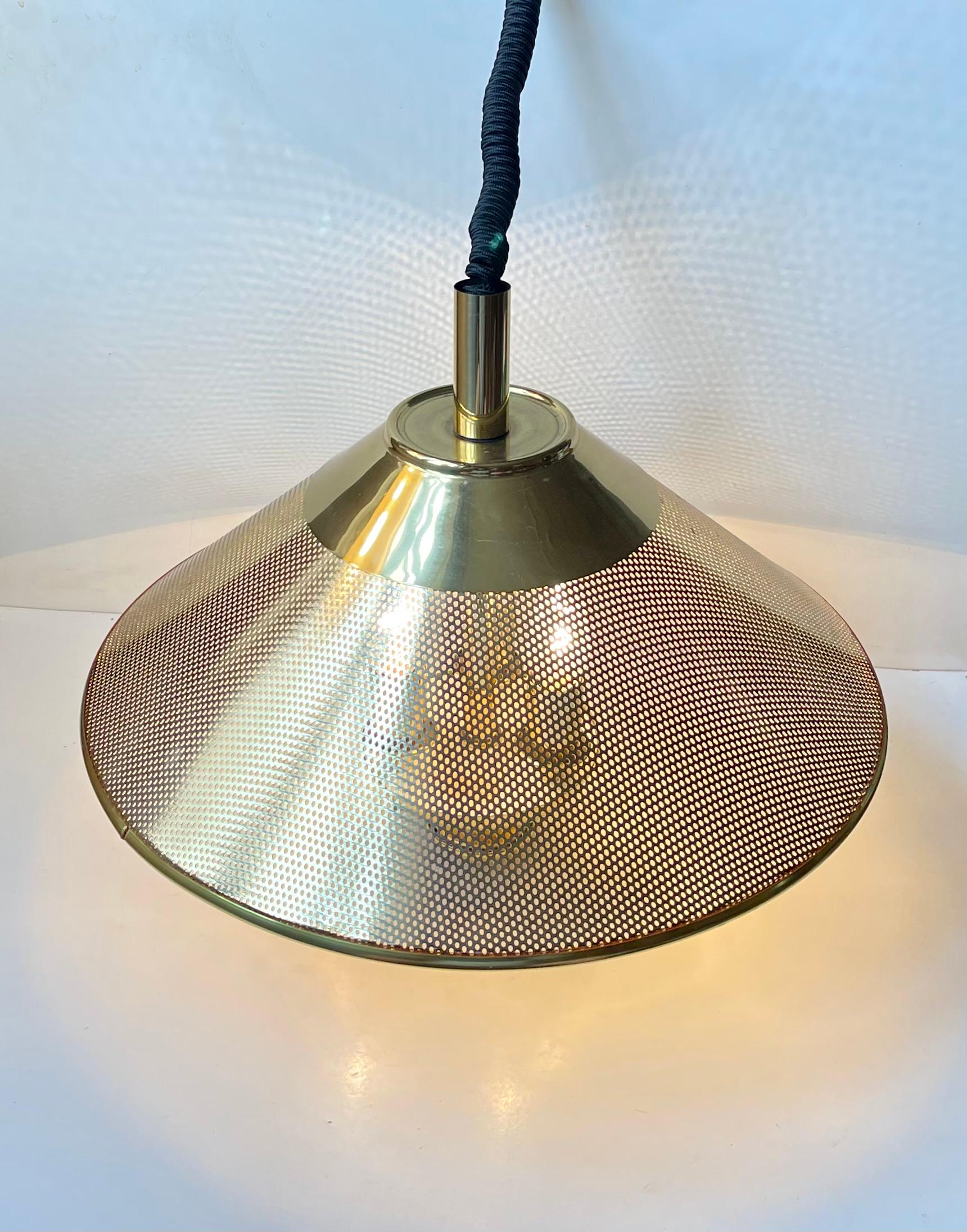 A stylish height adjustable vintage Danish hanging Lamp. The style is Nautical/Maritime and it will add a cosy twist to any modern interior. The light is in a very nice vintage condition with light ware and natural patination to the solid brass. It