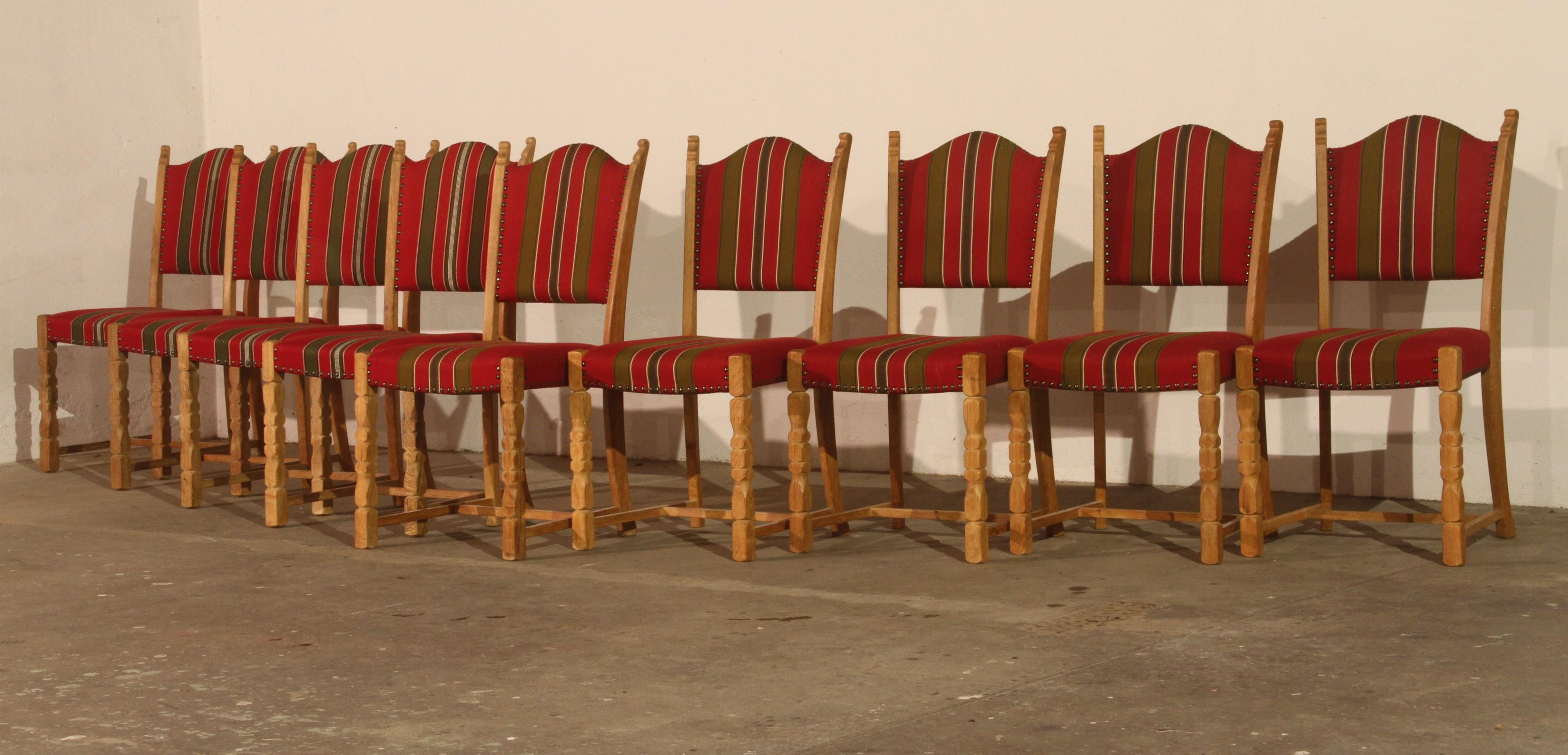 A set of 9 vintage oak dining chairs crafted in Denmark in the 1960s/70s, inspired by Henning Kjærnulf’s Brutalist / Baroque Bold style. Each chair is solid with no damage to the wood, and the fabric is in excellent, nearly new condition, with the