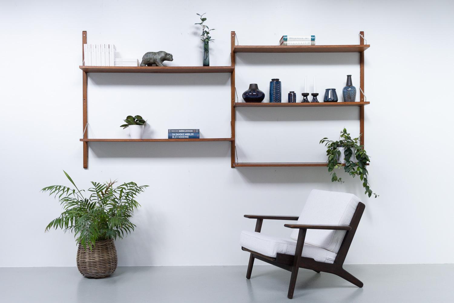 Vintage Danish Oak Shelving System, 1960s.
Wall unit with shelves in oak. The upright and the metal brackets are from the Poul Cadovius System Royal. The long shelves in solid oak are custom made.
This set consists of:
3 uprights in stained beech,