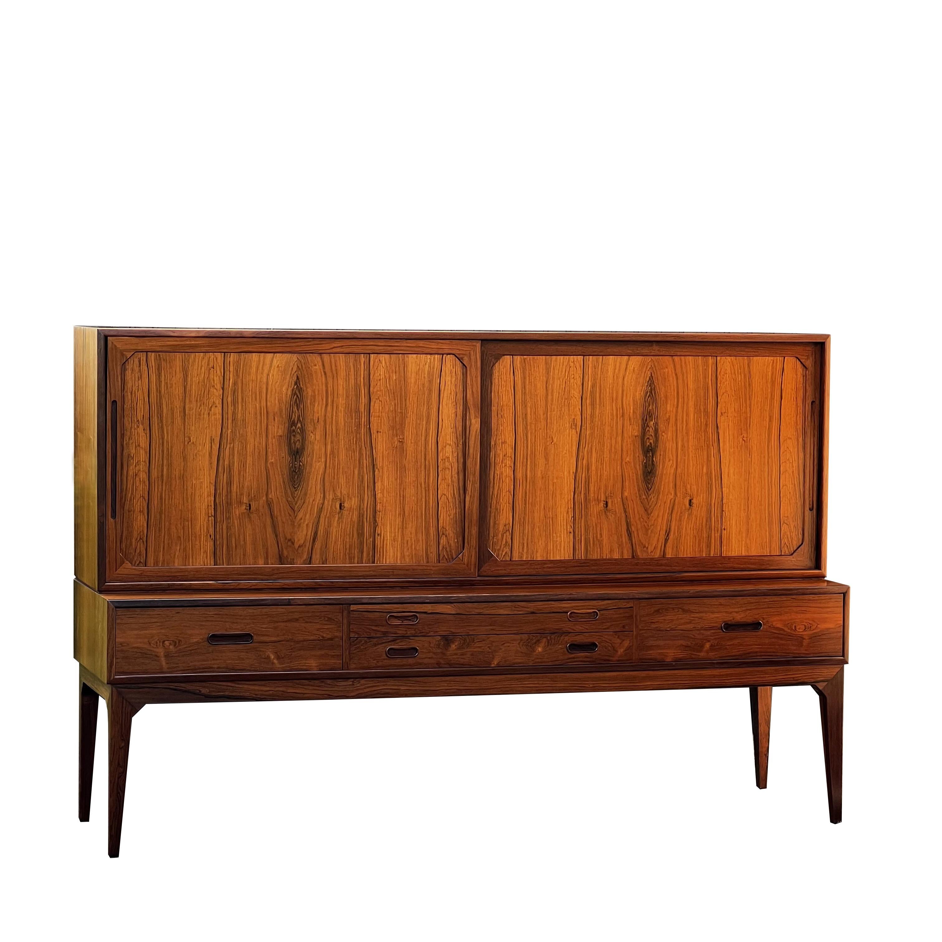 Tall sideboard, designed by Severin Hansen in Denmark in the 1960s. The piece opens with two sliding doors and four drawers at the bottom. The two sliding doors reveal two large compartments with height-adjustable shelves and three trays. The