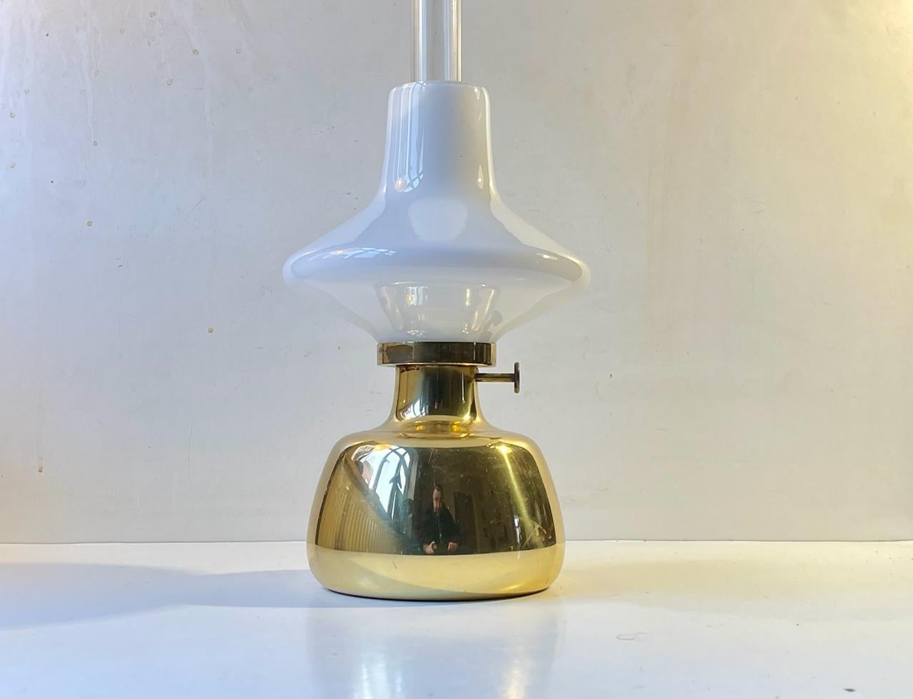 Conçue par Henning Koppel (1918-81) dans les années 60 et fabriquée par Louis Poulsen dans les années 70, la lampe à huile Petronella est fabriquée en laiton massif et possède un abat-jour en verre opalin avec une cheminée interne en verre clair.