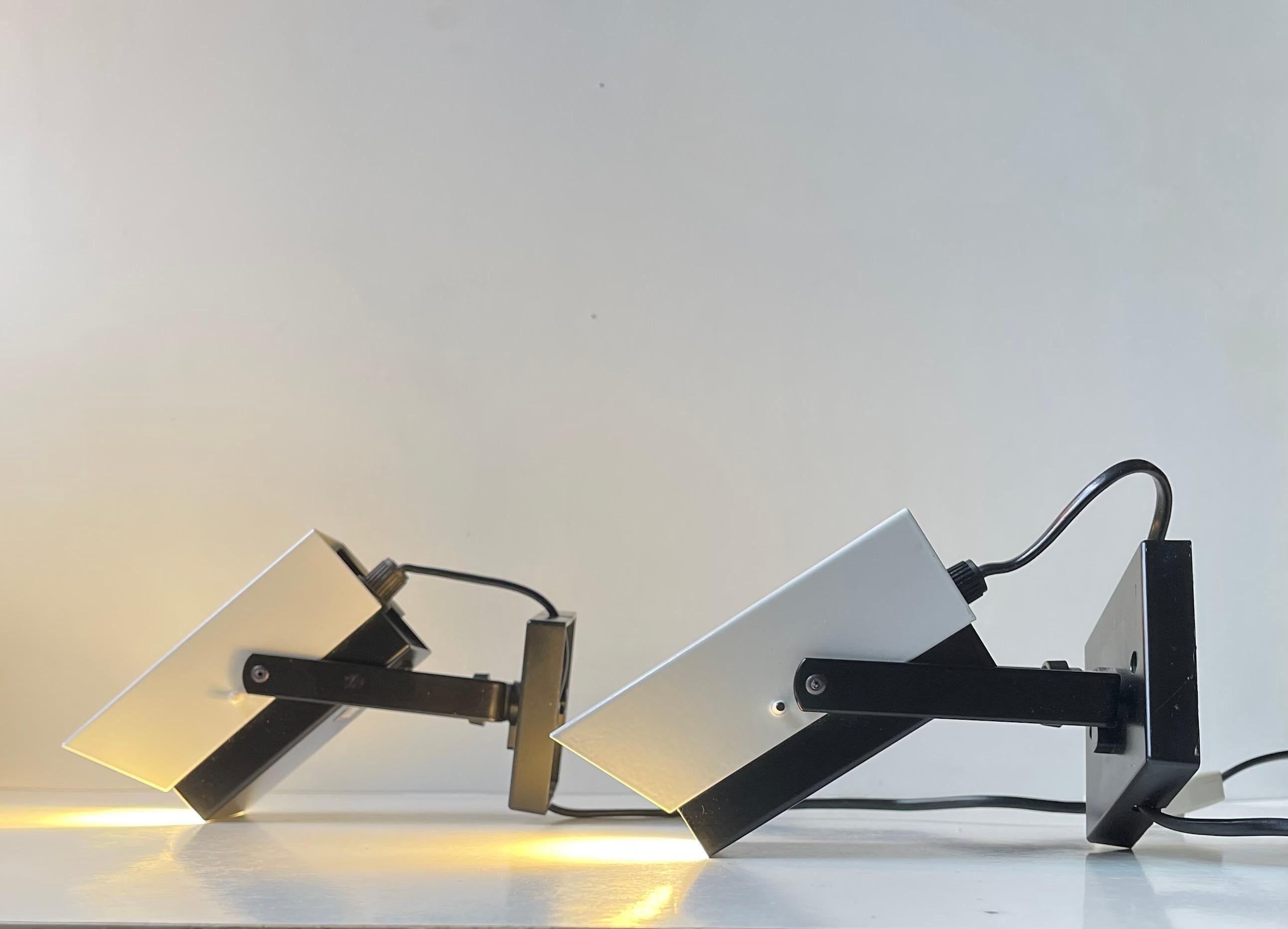 A pair of adjustable wall or night light fashioned in powder-coated steel. A black and a white half featuring strict geometric almost graphic lines. Designed and made by Davids Lampe in Denmark circa 1970-75. For the US. It will come installed with