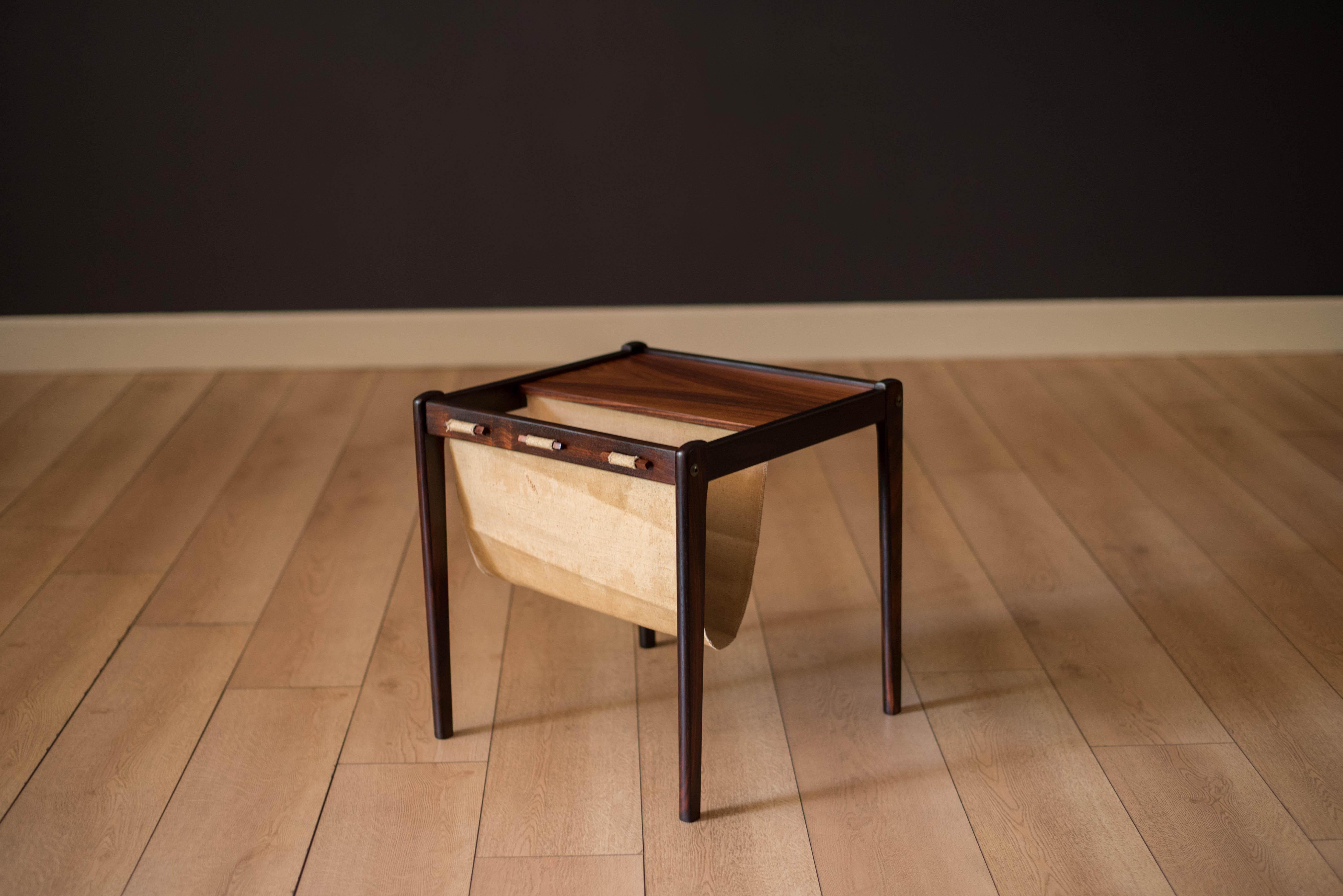 Mid-Century Modern magazine rack in rosewood by Bent Silberg Mobler, circa 1970s Denmark. This versatile piece features a canvas sling that holds light reading Material equipped with a functional side table.
