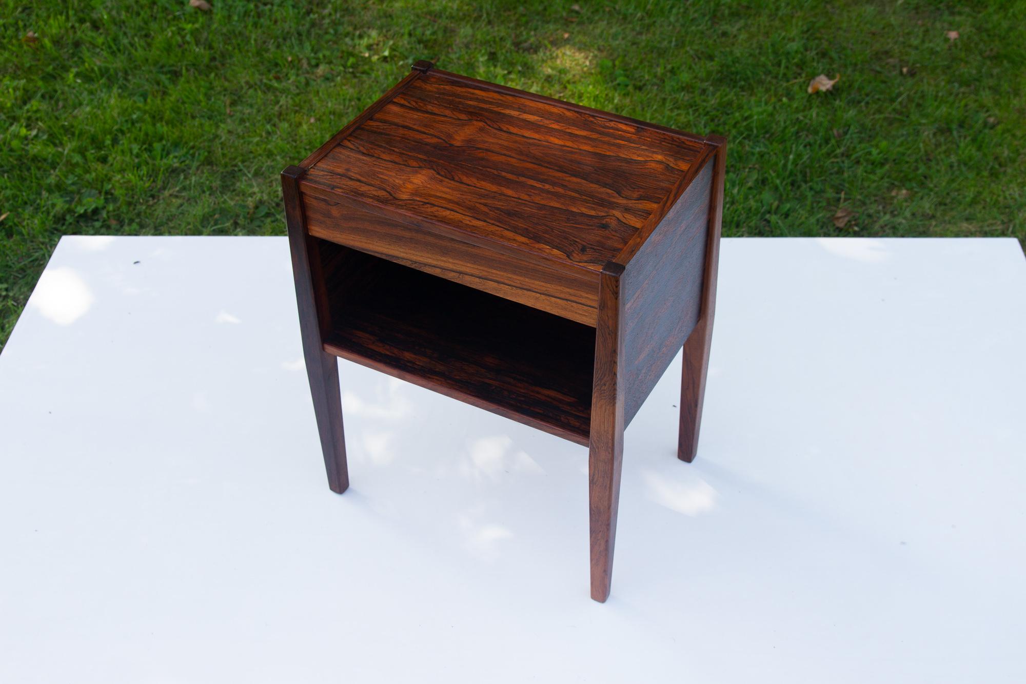 Vintage Danish rosewood bedside table 1960s.
Elegant small side table in Rosewood with open shelf and drawer. Very expressive veneer patterns. Tapered legs. Manufactured in Denmark in the 1960s.
Suitable for multiple purposes as side table, lamp
