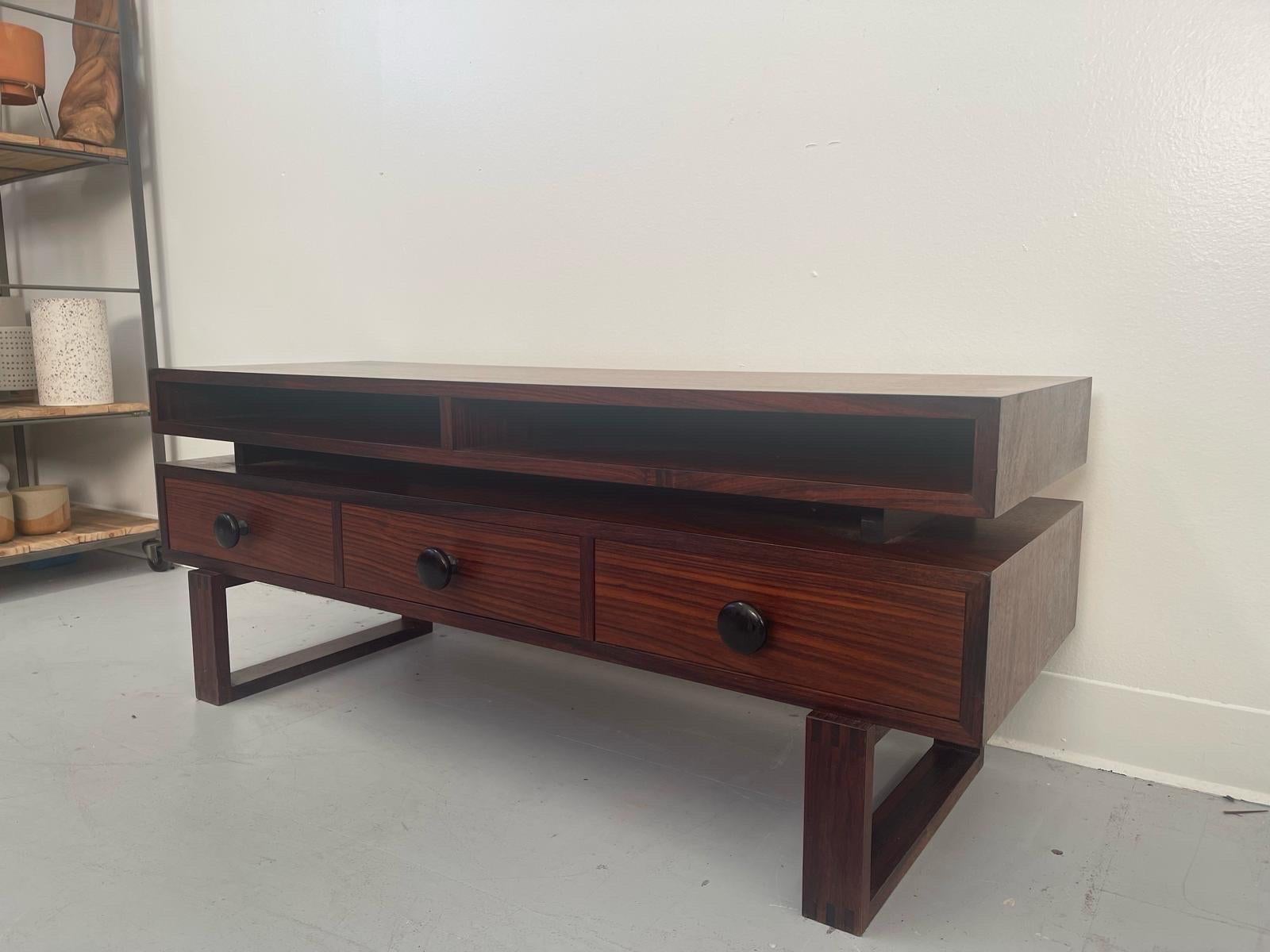Danish design Coffee Table features wood Inlay accent on the top of the legs. Three dovetailed drawers. Top shelf is slightly elevated.Beautiful turned wood handles. Vintage Condition Consistent with Age as Pictured.

Dimensions. 42 W ; 15 D; 17 1/2