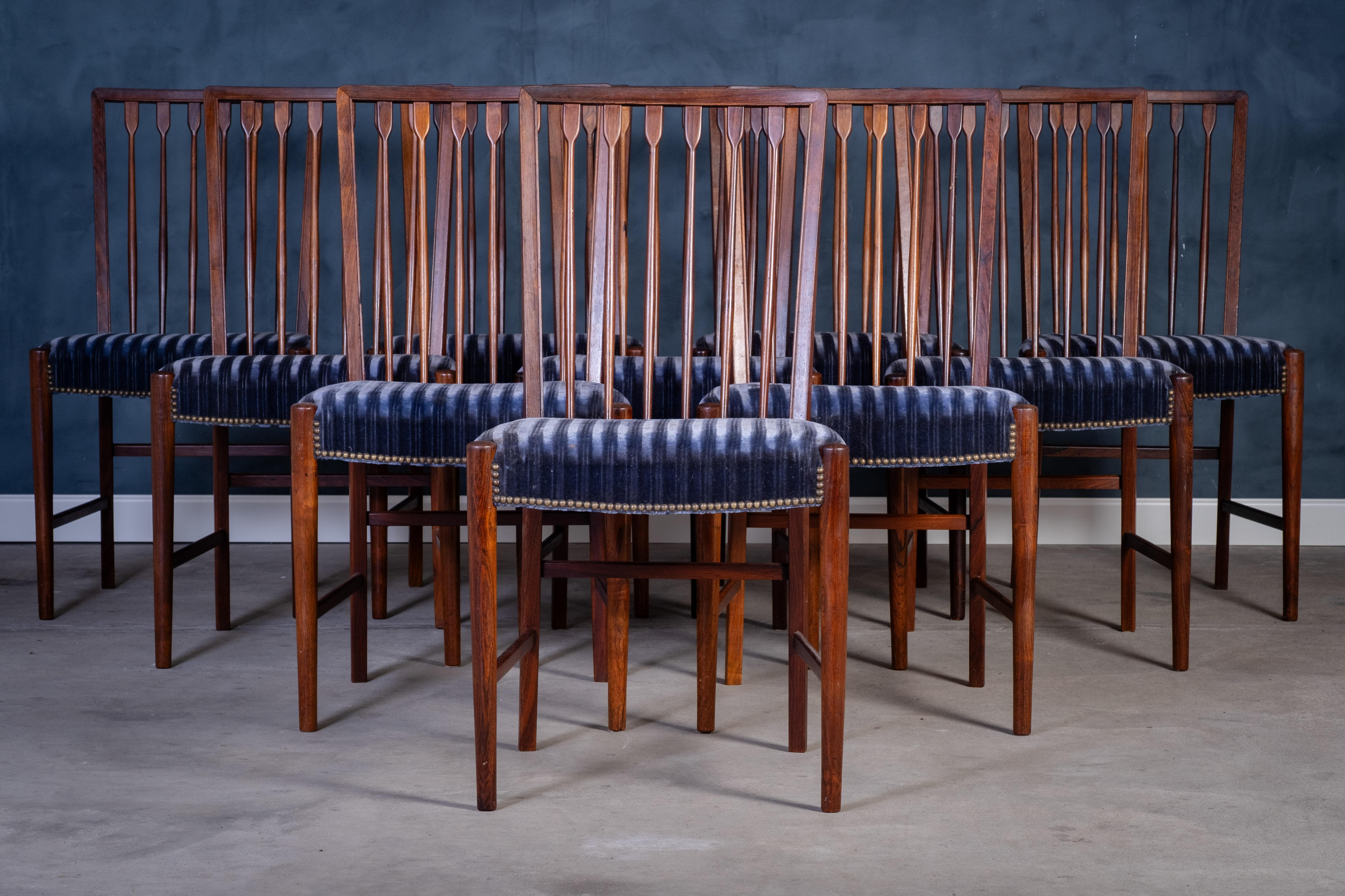 Eccezionale set di 10 sedie da pranzo in legno di palissandro riccamente venato, prodotto in Danimarca negli anni '50 da un ebanista sconosciuto. Le sedie mostrano un'eccezionale maestria artigianale, con una falegnameria raffinata e dettagli