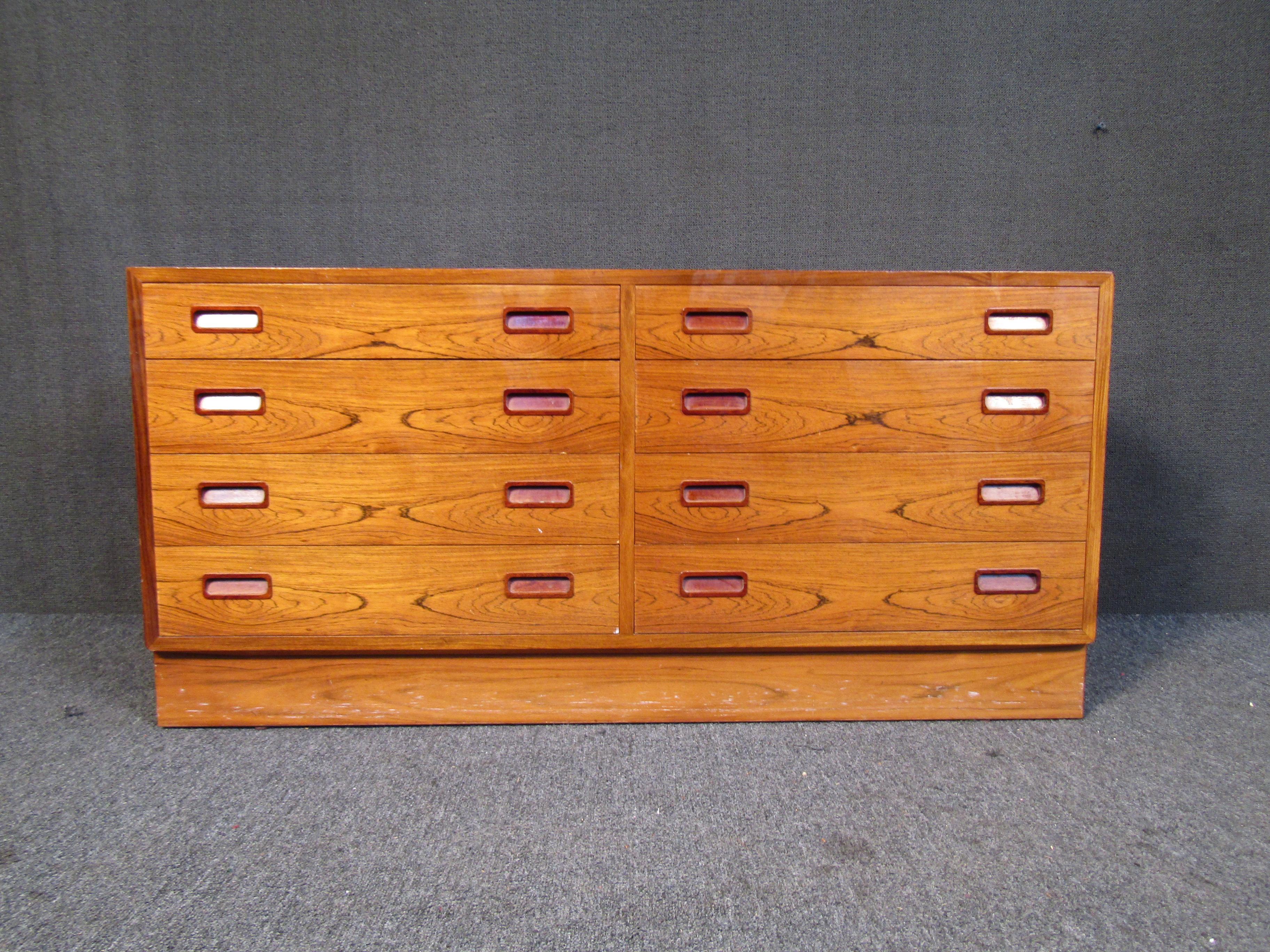 This Danish dresser combines vibrant rosewood with quality Mid-Century craftsmanship, generous storage, and unique drawer pulls. Please confirm item location with seller (NY/NJ).