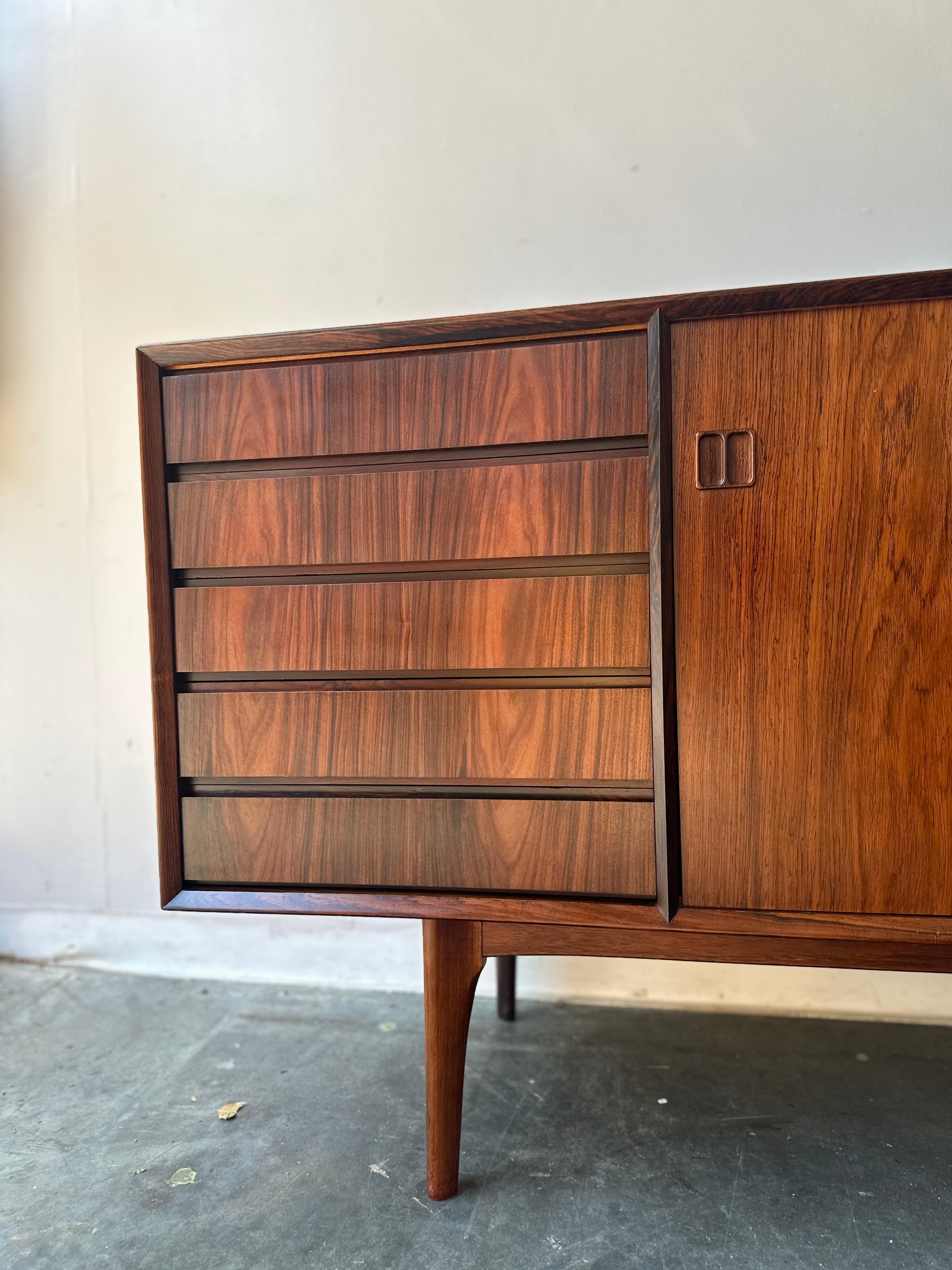 Restaurata professionalmente alla perfezione.

La credenza scandinava presenta una squisita lavorazione artigianale, evidenziata dal suo profondo palissandro color sangue di bue e dalle sorprendenti venature a cattedrale. I motivi ricchi e svasati
