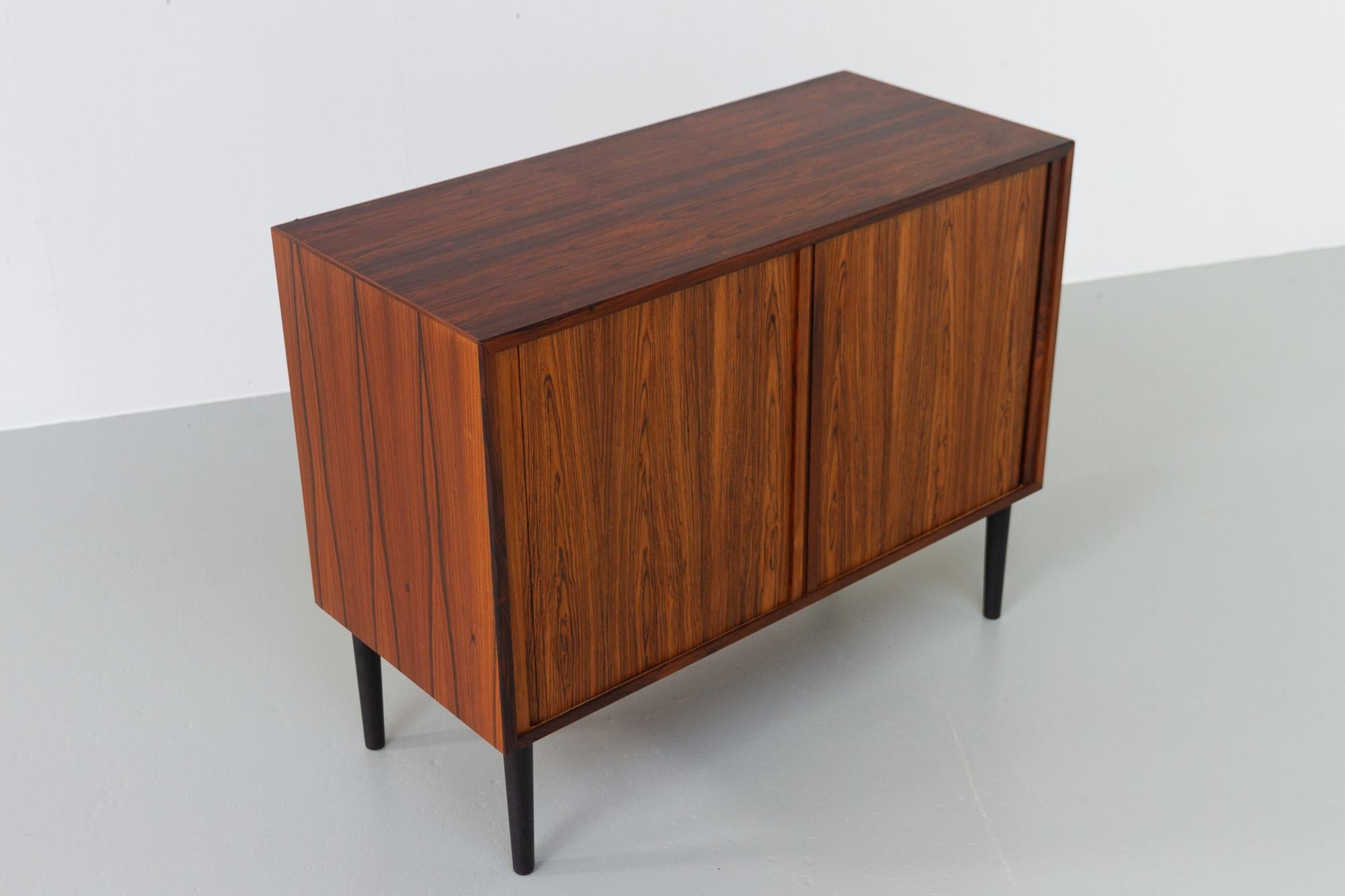 Vintage Danish Rosewood Sideboard with Tambour Doors by HG Furniture, 1960s.
Designed by Rud Thygesen og Johnny Sørensen for Hansen & Guldborg, Denmark.
This small Mid-Century Modern Rosewood sideboard is part of the HG Wall unit system. The