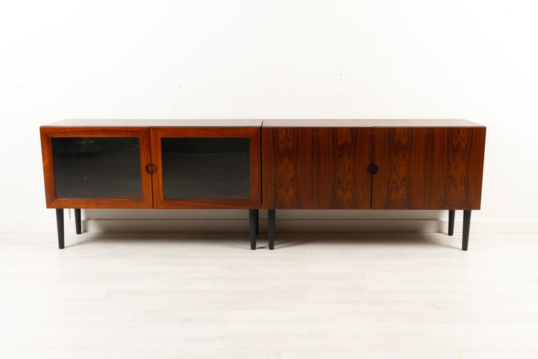 Vintage Danish Rosewood Sideboards by Sven Ellekær for Bramin Møbler 1970s
Pair of Danish Mid-century modern cabinets in Rosewood. 
One cabinet with double hinged doors. One cabinet with double hinged glass doors and vertical divider. Both with