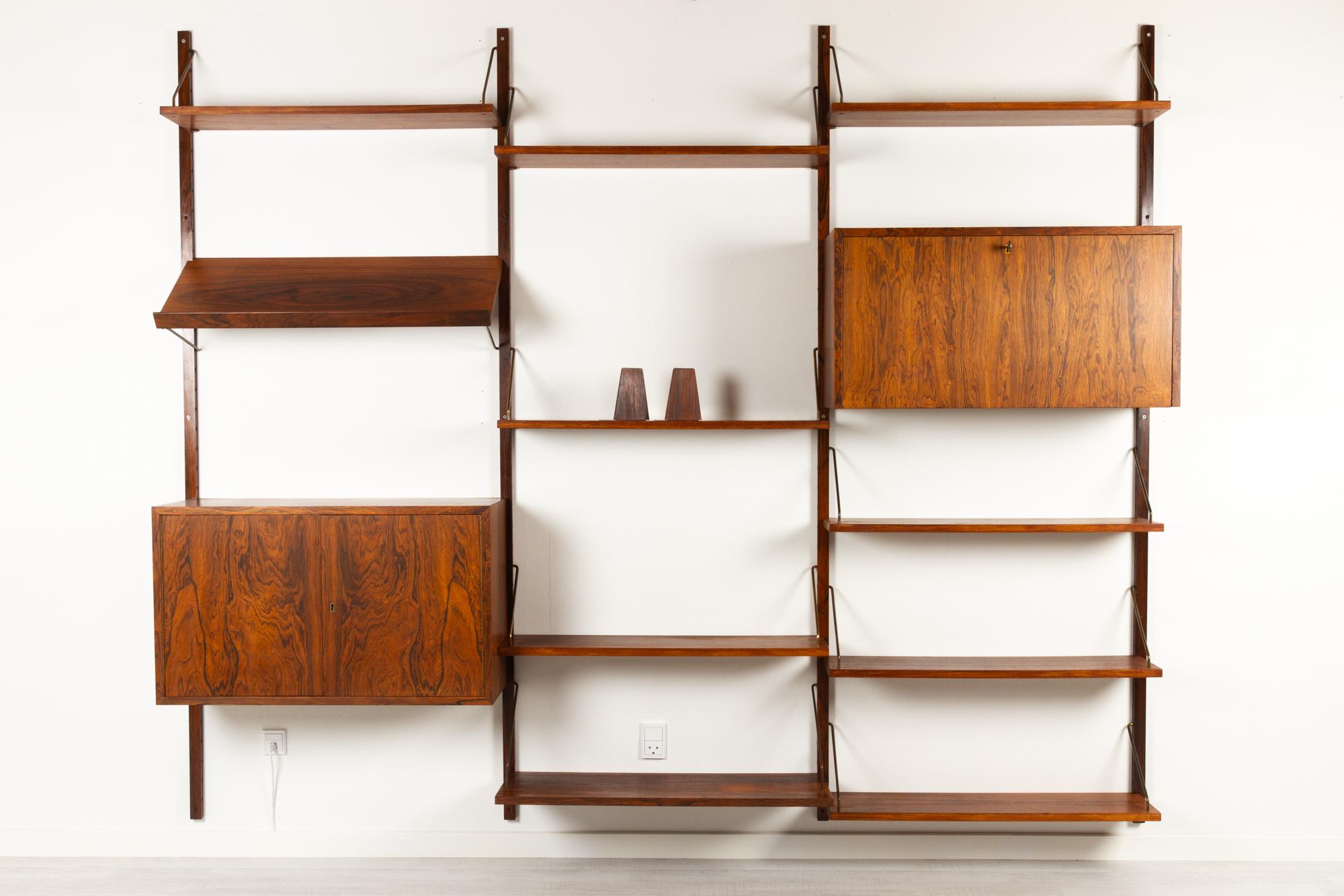 Vintage Danish rosewood wall unit, 1960s
3 bay Mid-Century Modern modular shelving system in Rosewood veneer. All shelves and cabinets can be placed and moved around as desired. Very expressive and vivid grain pattern on this wall-mounted bookcase.