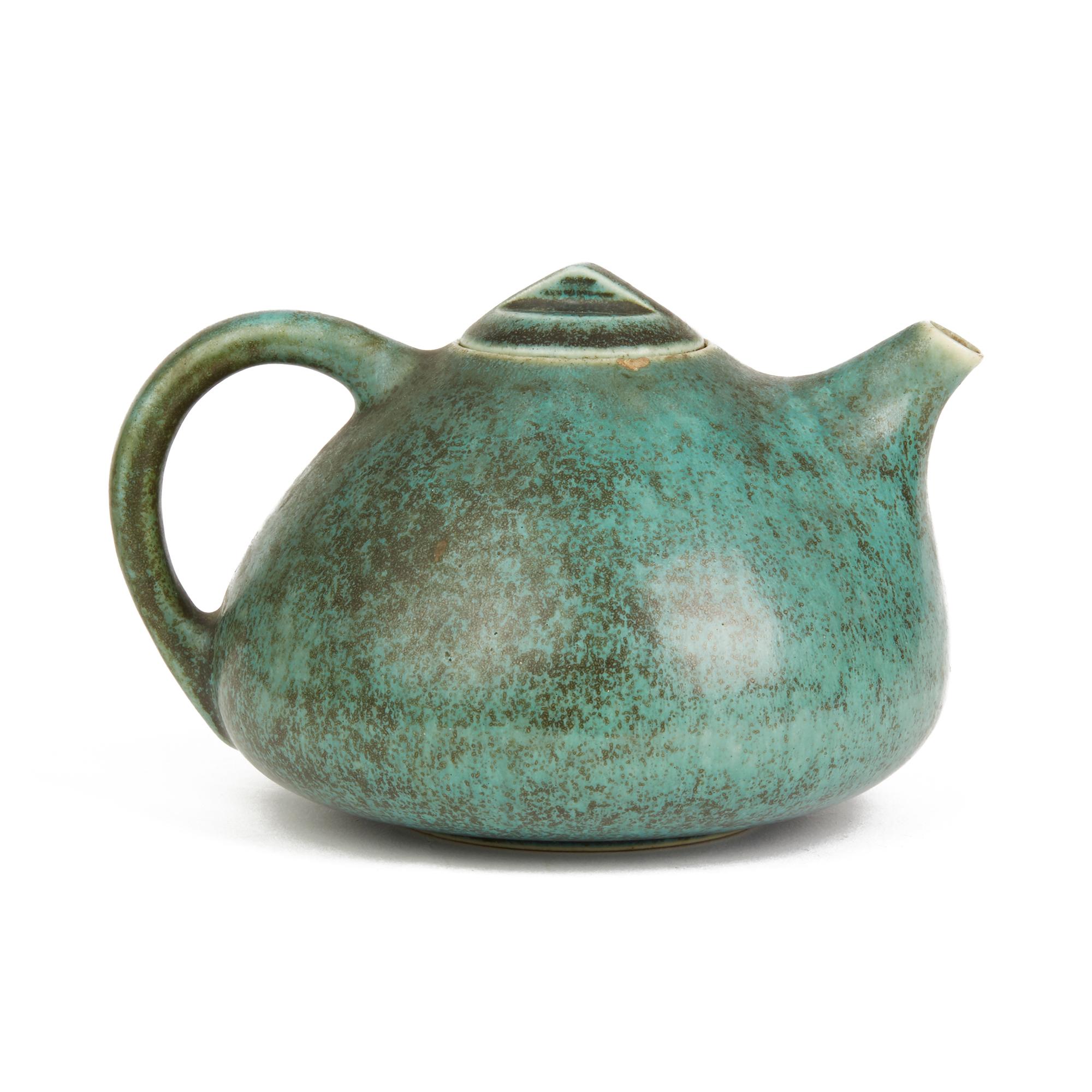 A scarce vintage Danish Saxbo stoneware teapot designed by Eva Stæhr-Nielsen. The teapot of squat rounded form has a fitted angular cover with small pouring spout and loop handle and is decorated in satin mottled brown and green glazes. The teapot
