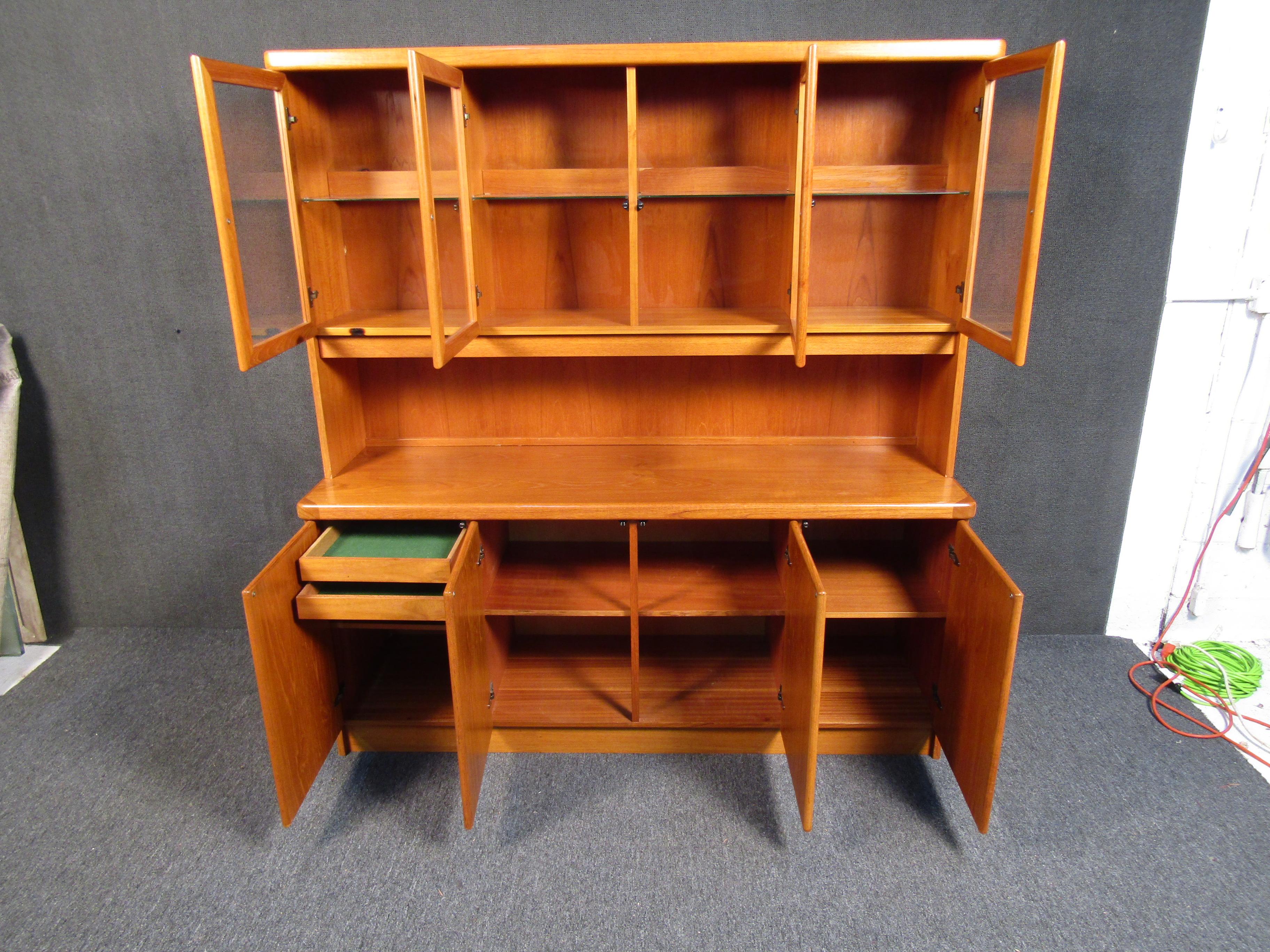Featuring glass windows, multiple shelves for storage, and rich woodgrain, this Danish Mid-Century piece is versatile and full of classic style. Please confirm item location with seller (NY/NJ).