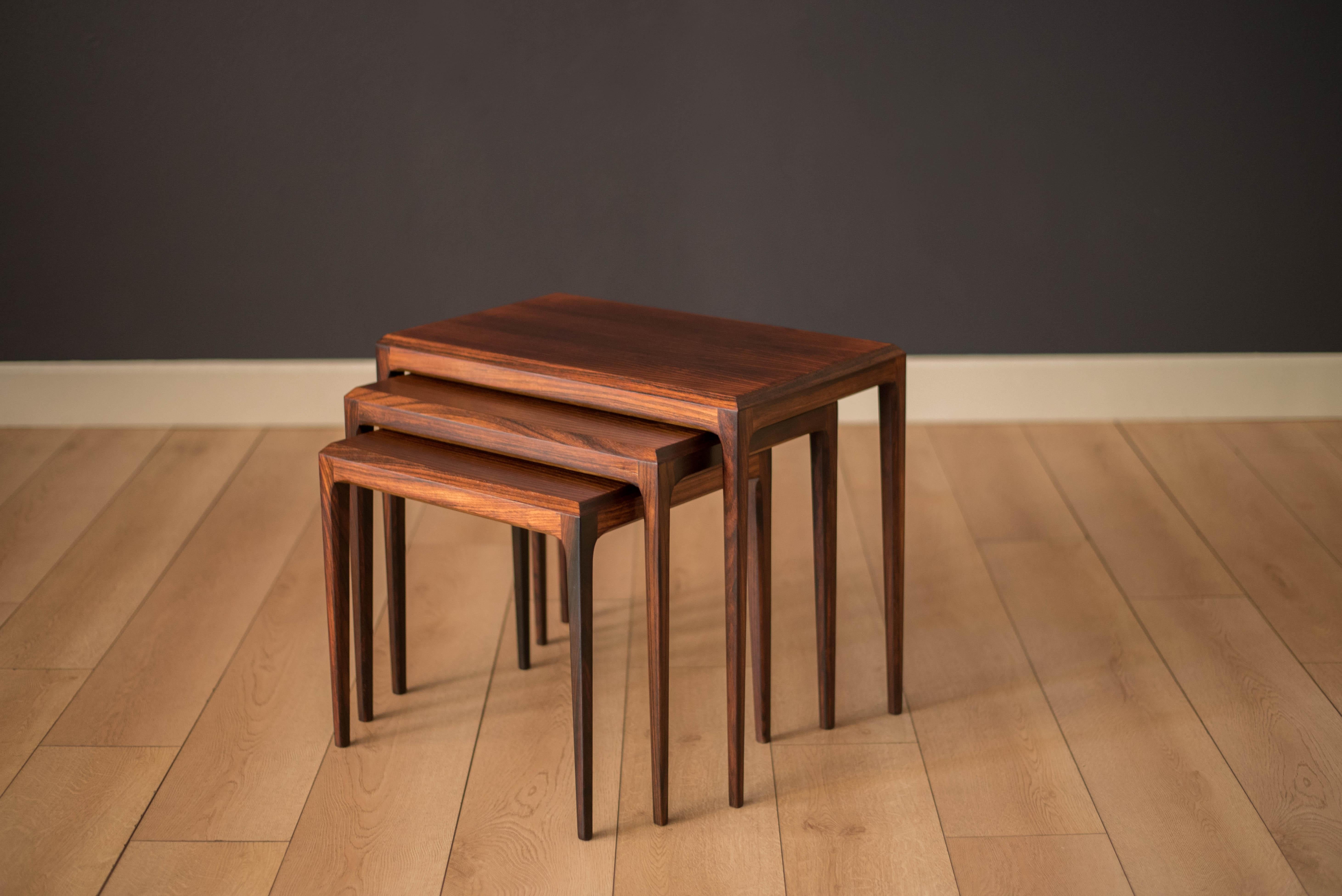 Mid-Century Modern nesting tables by Johannes Andersen for CFC Silkeborg made in Denmark. This versatile set features Brazilian rosewood with contoured edges and tapered legs.

Largest end table: 23.75