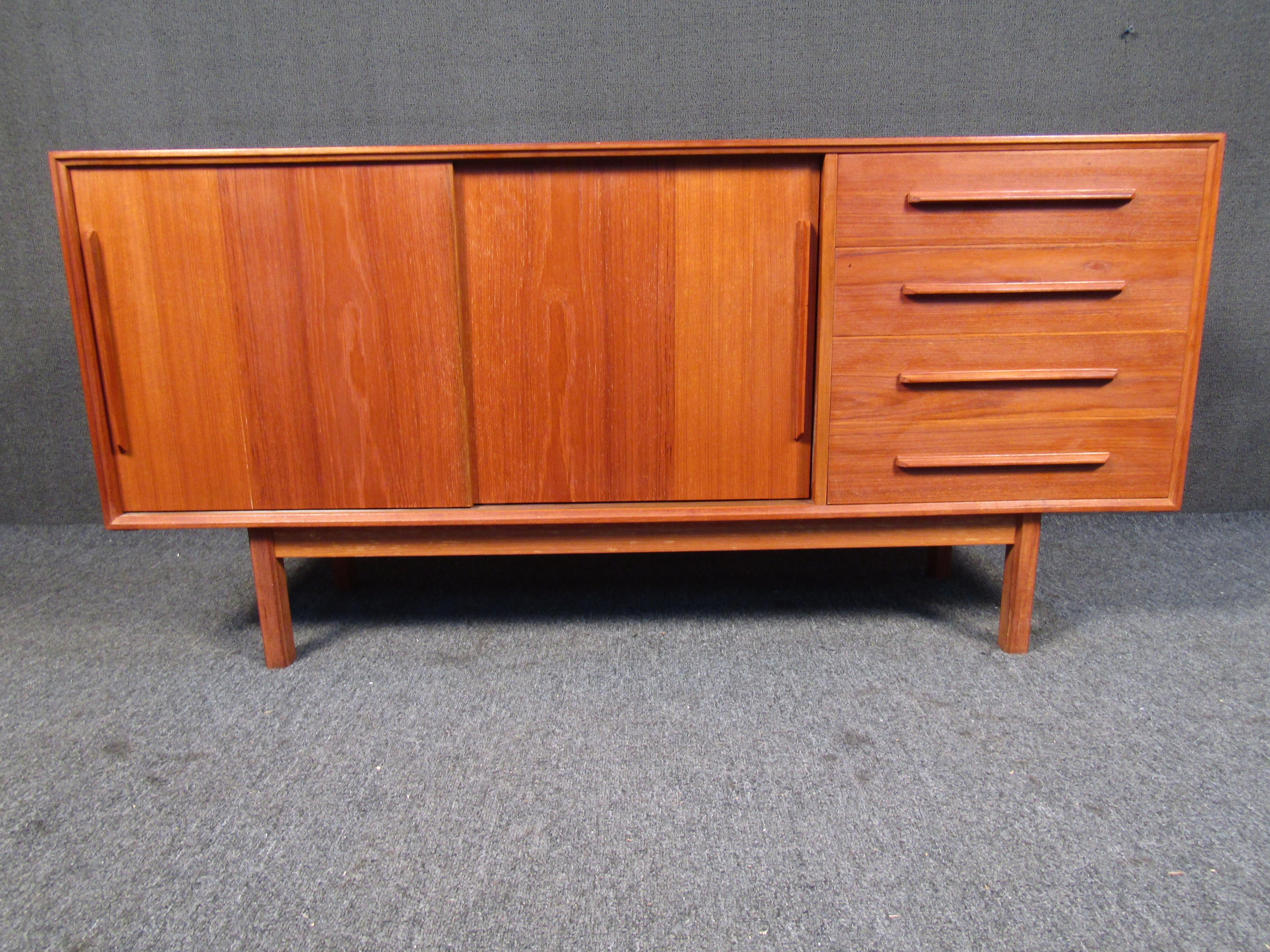 This vintage Danish sideboard shows off a rich teak woodgrain paired with plenty of drawer and storage space. Please confirm item location with seller (NY/NJ).