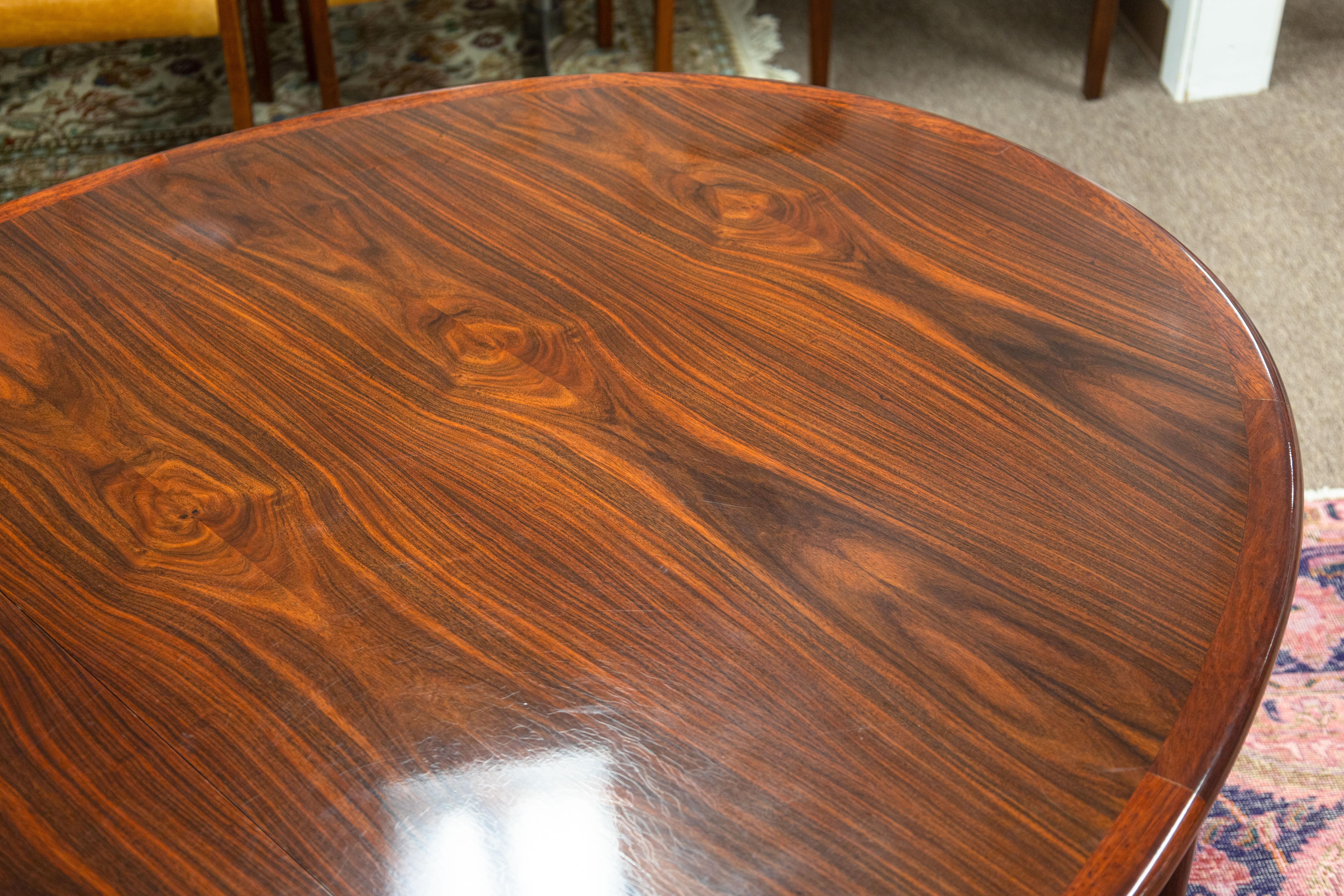 A vintage Skovby extendable dining table. This is an absolutely stunning Danish dining table featuring a lovely rosewood construction. The wood has a beautiful color and grain texture that is very unique to just rosewood which is no longer produced