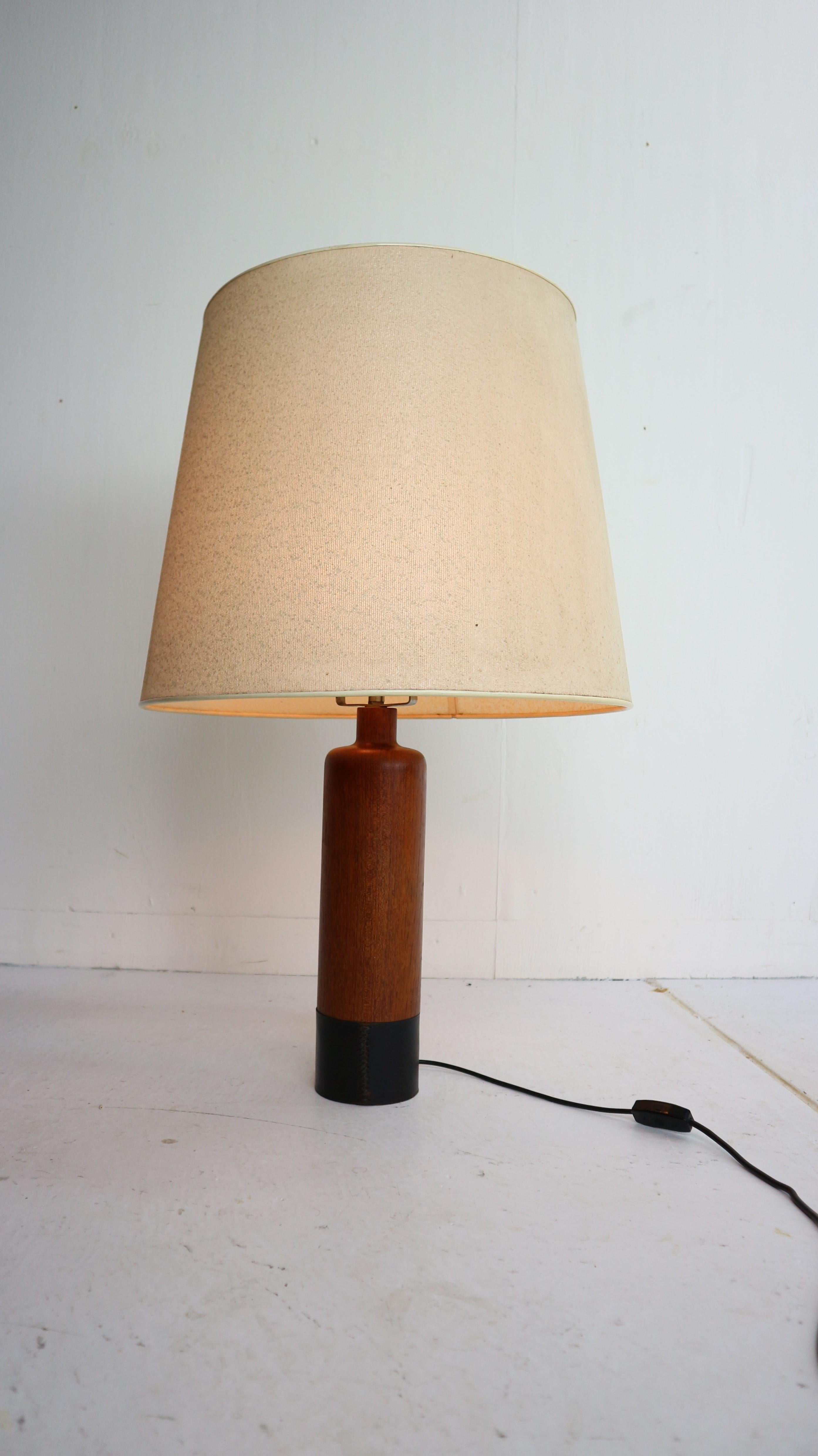 Cylindrical table lamp by ESA, Denmark, circa 1960.
Solid teak feed complemented by a black-leather wrapped base. 
Two lamp sockets and the original vintage shade.
 