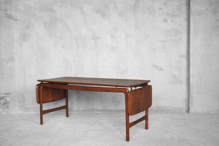 This both stunning and simple adjustable coffee table was designed in 1956 by Peter Hvidt & Orla Mølgaard-Nielsen for France & Daverkosen. It is a perfect example of Danish Modern design. In full, it was made of solid teak wood and brass hardware.