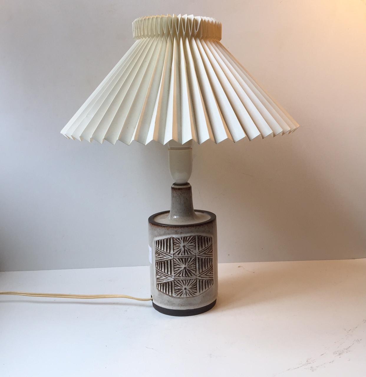 Vintage Danish Stogo stoneware table lamp with sunburst center motif. It was designed by ceramist H. Gottschalk-Olsen in the 1970s and manufactured at Stogo Studio. Stamped with both maker marks and designer initials to the base. The table lamp is