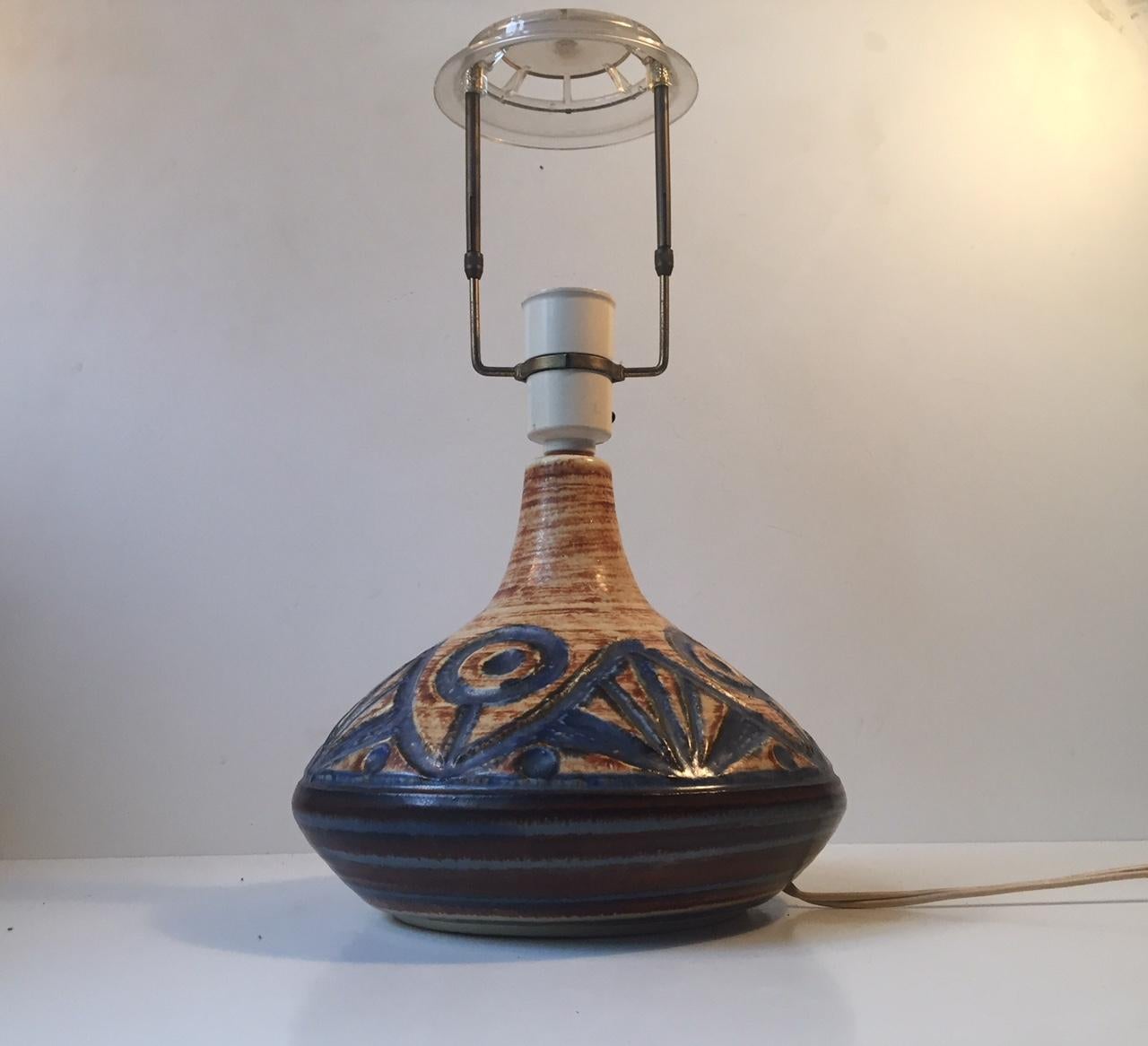 This stoneware table lamp is decorated with an abstract floral pattern. It was designed by Noomi Bachausen and manufactured by Søholm in Denmark during the 1960s. This lamp doesn't include the lampshade. Please personalize with your own.