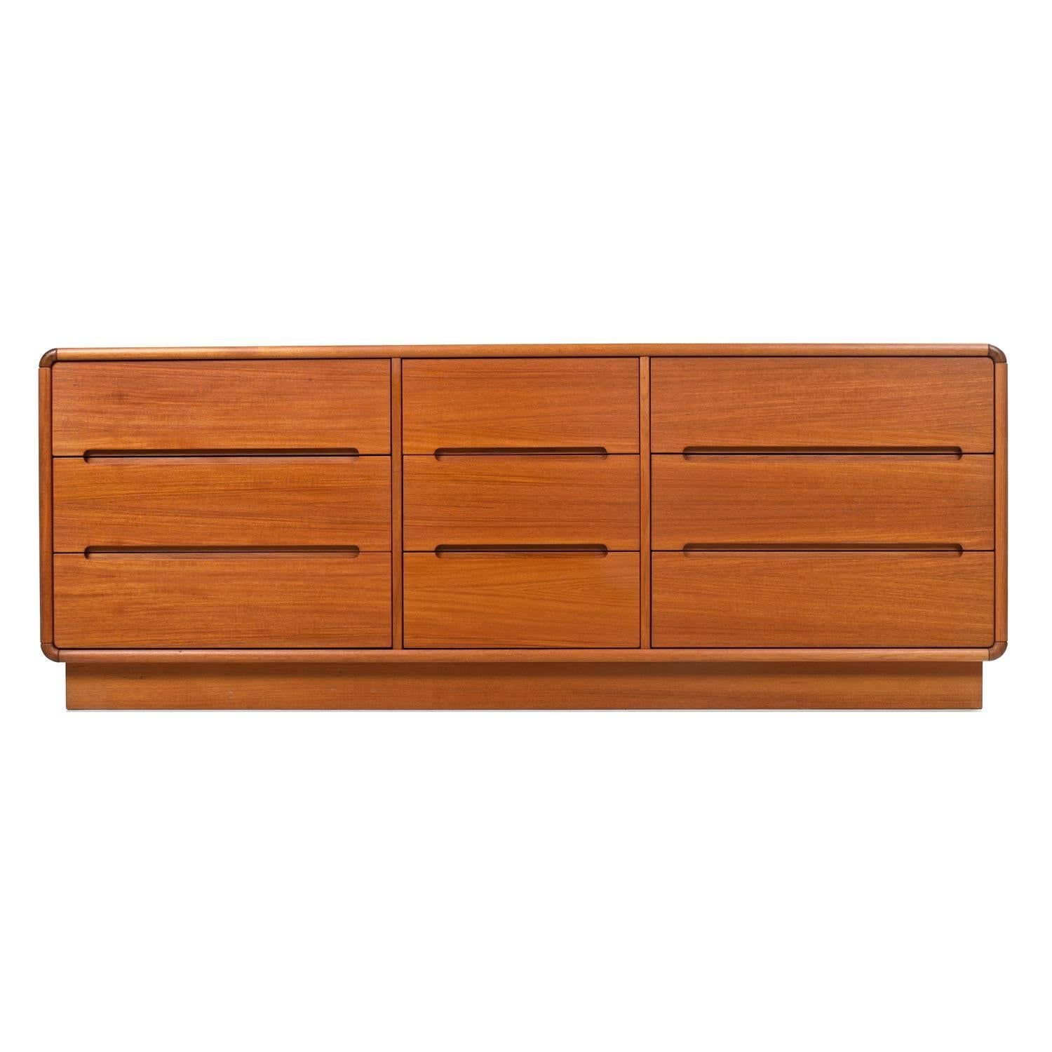 Quelques décennies de patine ont enrichi la couleur et accentué le grain fin de cette belle pièce. Neuf tiroirs spacieux et profonds offrent un espace de rangement suffisant pour vos vêtements. L'épais socle en forme de plinthe est une véritable